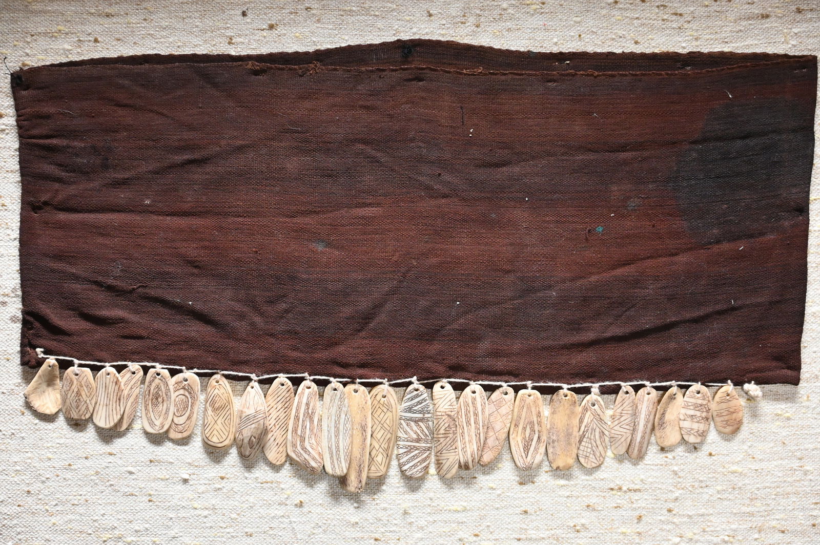 Vintage Shipibo-Conibo Baby Sling with Incised Bone Pendants.: Vintage Shipibo-Conibo Baby Sling with Incised Bone Pendants. Handwoven cotton 22" x 9" with 25 great detailed incised bone rattle pendants 3" longest.