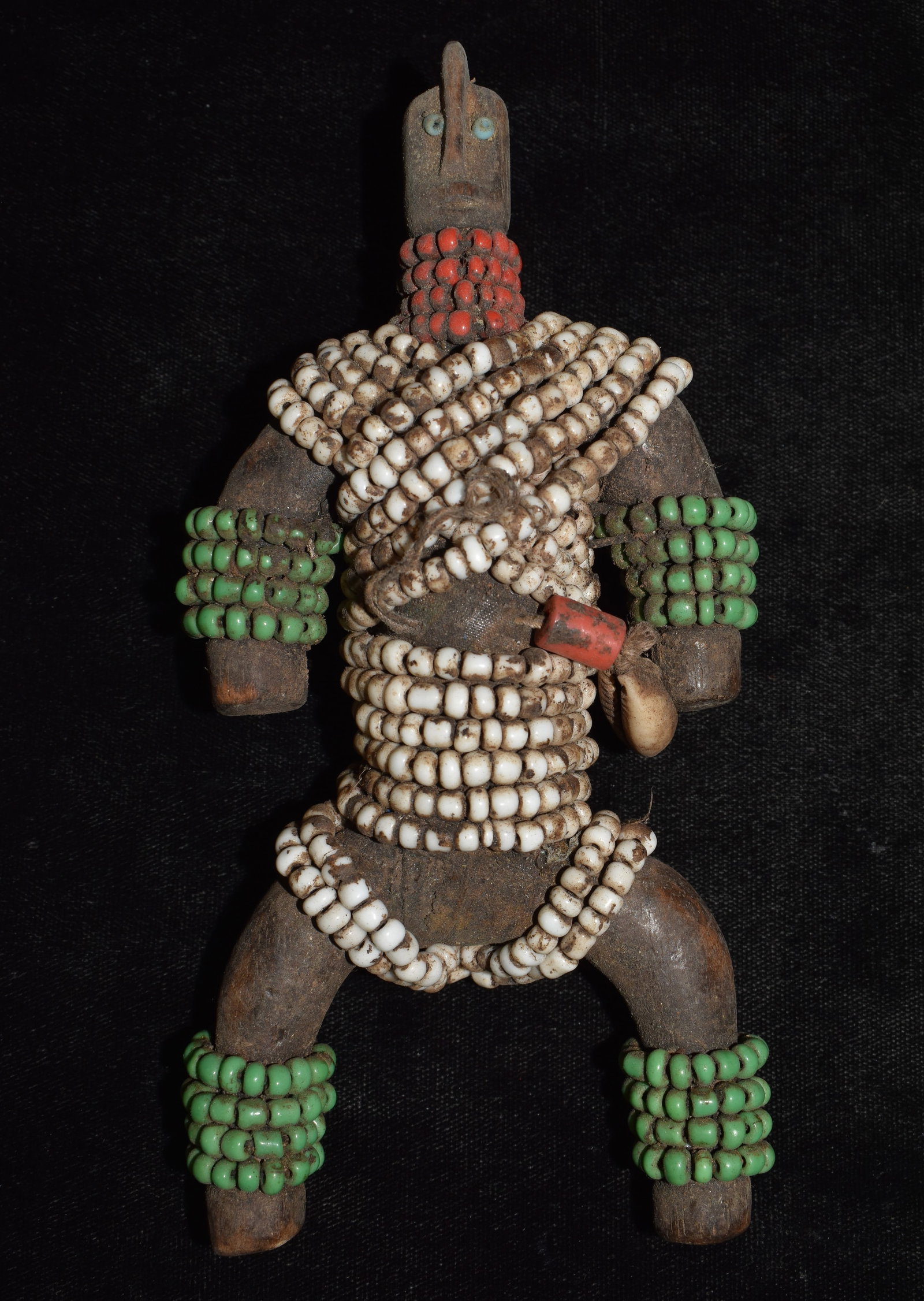 African Namji Fertility 6 3/4" Wood Doll: Beautifully crafted Namji fertility doll's originate from the Namji people of Cameroon. The doll is hand-carved from hard wood and adorned with colorful beads, leather strips, fiber, and cowry shells.
