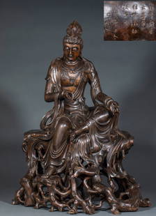 Agarwood Bodhisattva Avalokitesvara Statue: This is a rare large-scale round sculpture of a free and easy Guanyin made from agarwood with a dense and delicate fragrance. The figure is carved in the natural shape of the wood, with a relaxed sitt