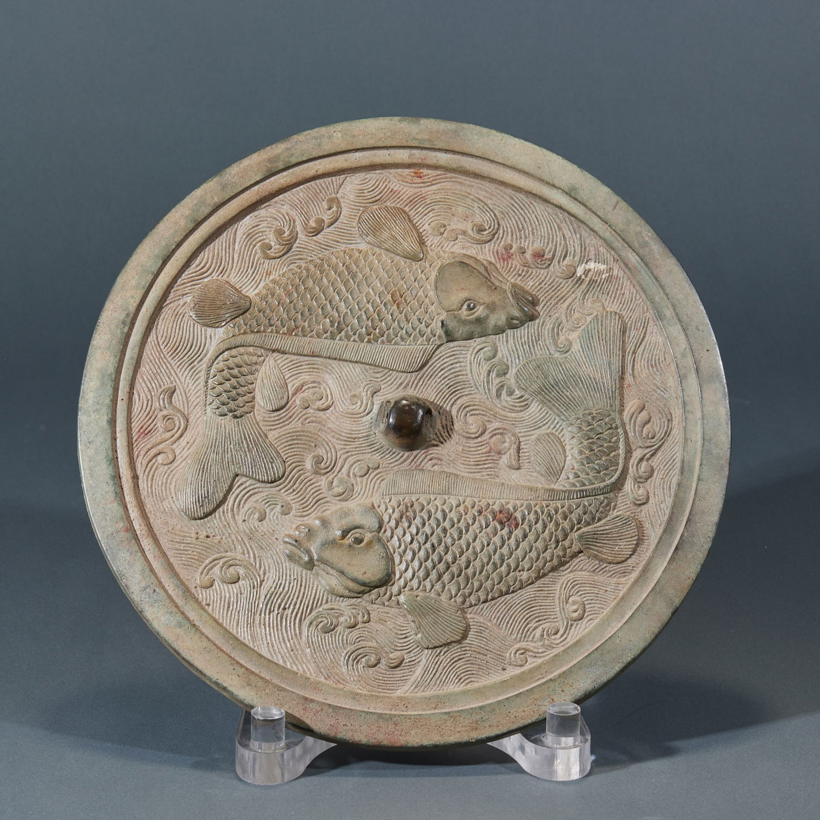 Before Ming Dynasty, double-fish copper mirror: A Bronze Mirror with Double Fish Design, Ming Dynasty or Earlier: Made of bronze, it features double fish and water wave patterns created through casting and relief carving techniques, with a symmetri