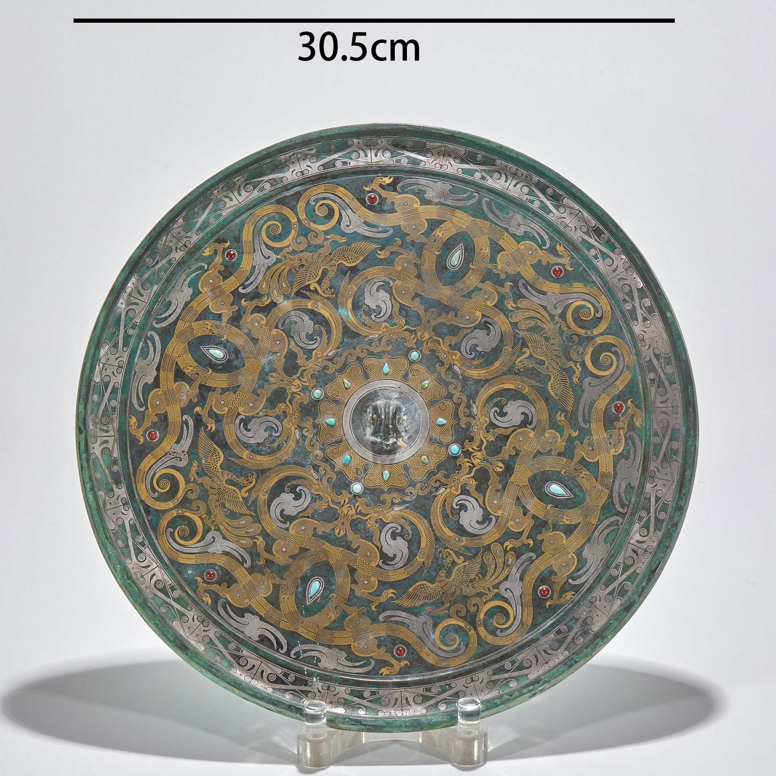Gold and Silver Inlaid Gemstone-Adorned Bronze Mirror with Dragon and Phoenix Motifs, Pre-Ming: Pre-Ming Dynasty Gold and Silver Inlaid Gemstone Dragon and Phoenix Pattern Bronze Mirror, diameter 30.5cm, bronze with gold and silver inlay and inlaid with turquoise and rubies. Adopting the "gold