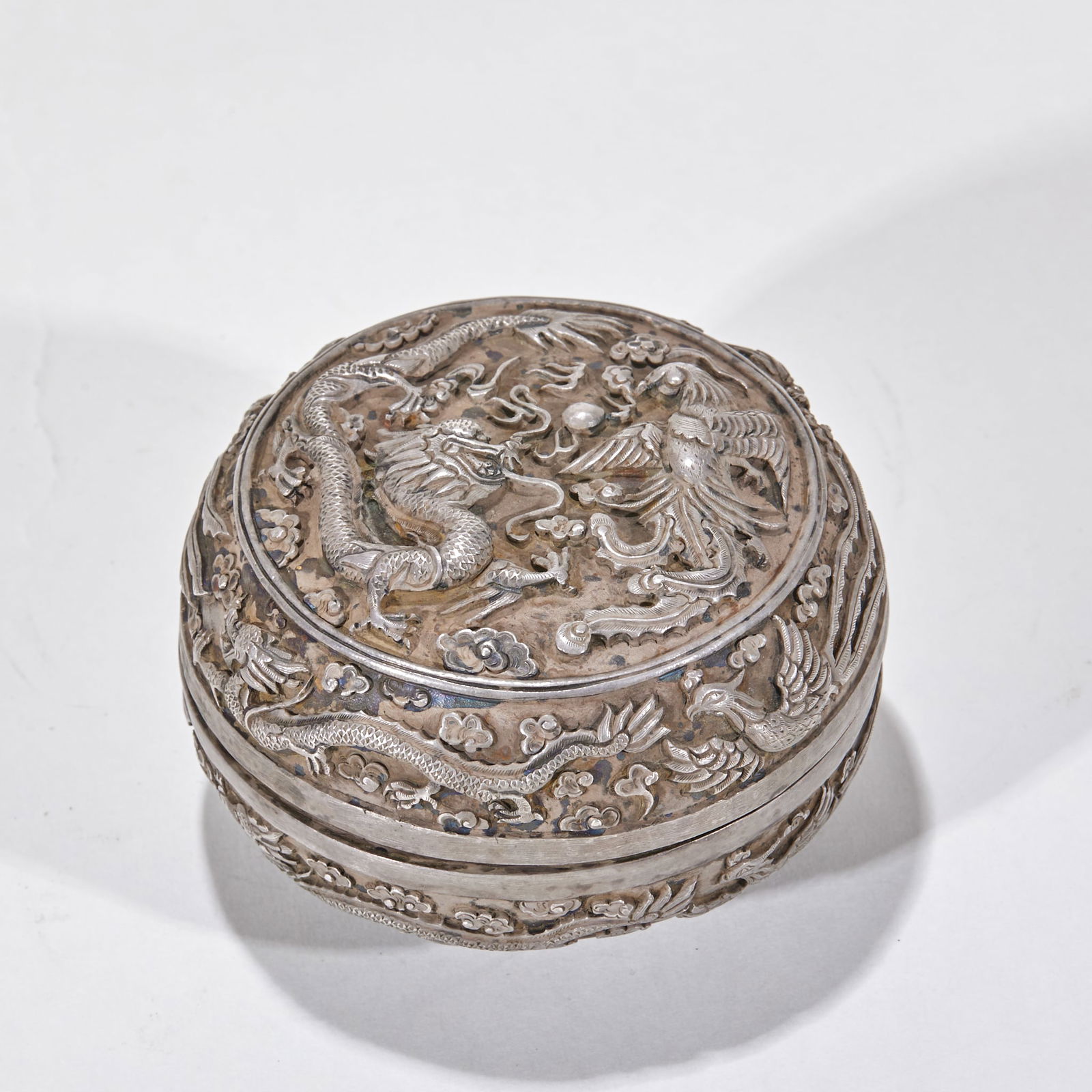 Lidded Box with Dragon and Phoenix Pattern, Pure Silver, Chiseled and Engraved: Pure Silver Carved Dragon and Phoenix Pattern Lidded Box, H: 5.3cm, D: 8cm, 190g. Produced in the Qing imperial workshop or a folk silver shop, it was a practical utensil for nobles to store jewelry a