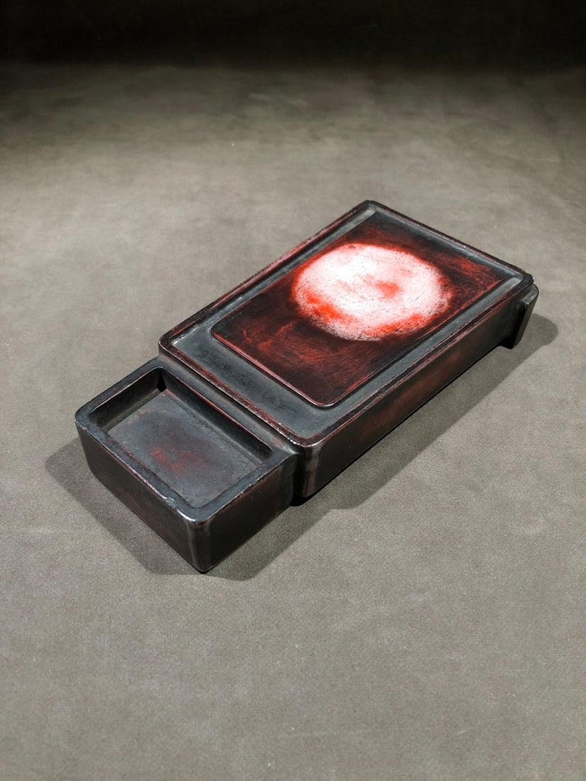 Cinnabar Inkstone, Marked Wang Youdun: Zhu Inkstone with the Mark of Wang Youdun, 18.5cm in length, 9.6cm in width and 3cm in thickness. Produced by the Imperial Workshop of the Qing Dynasty, it was an imperial study inkstone for Emperor