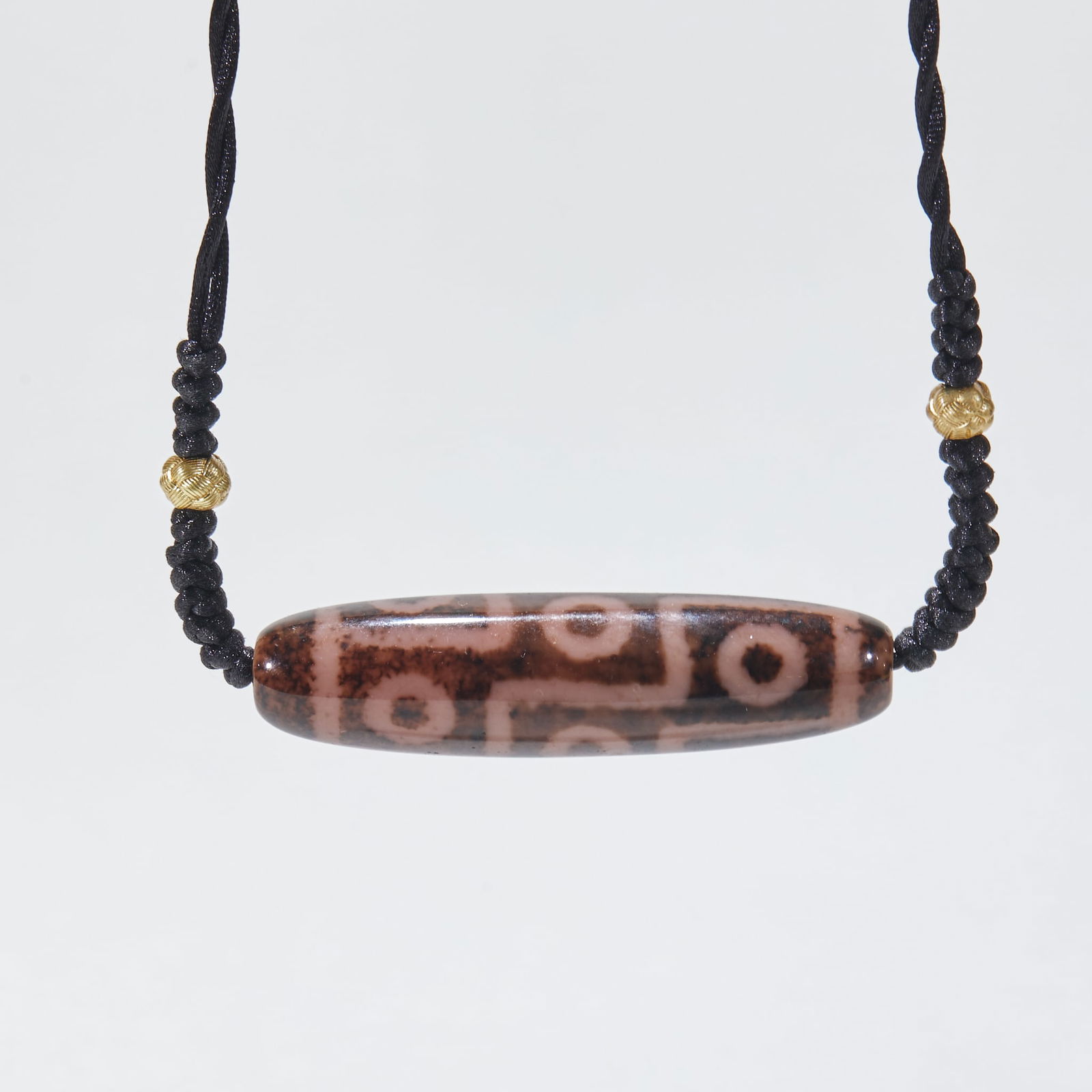 Nine-Eyed Dzi Bead, Agate: Agate Dzi Bead with Nine Eyes, 5.3cm in length, 1.3cm in diameter and 17g in weight. Produced by a workshop in the Xizang region or Persia in West Asia in the Tang Dynasty, it was an amulet worn by hi