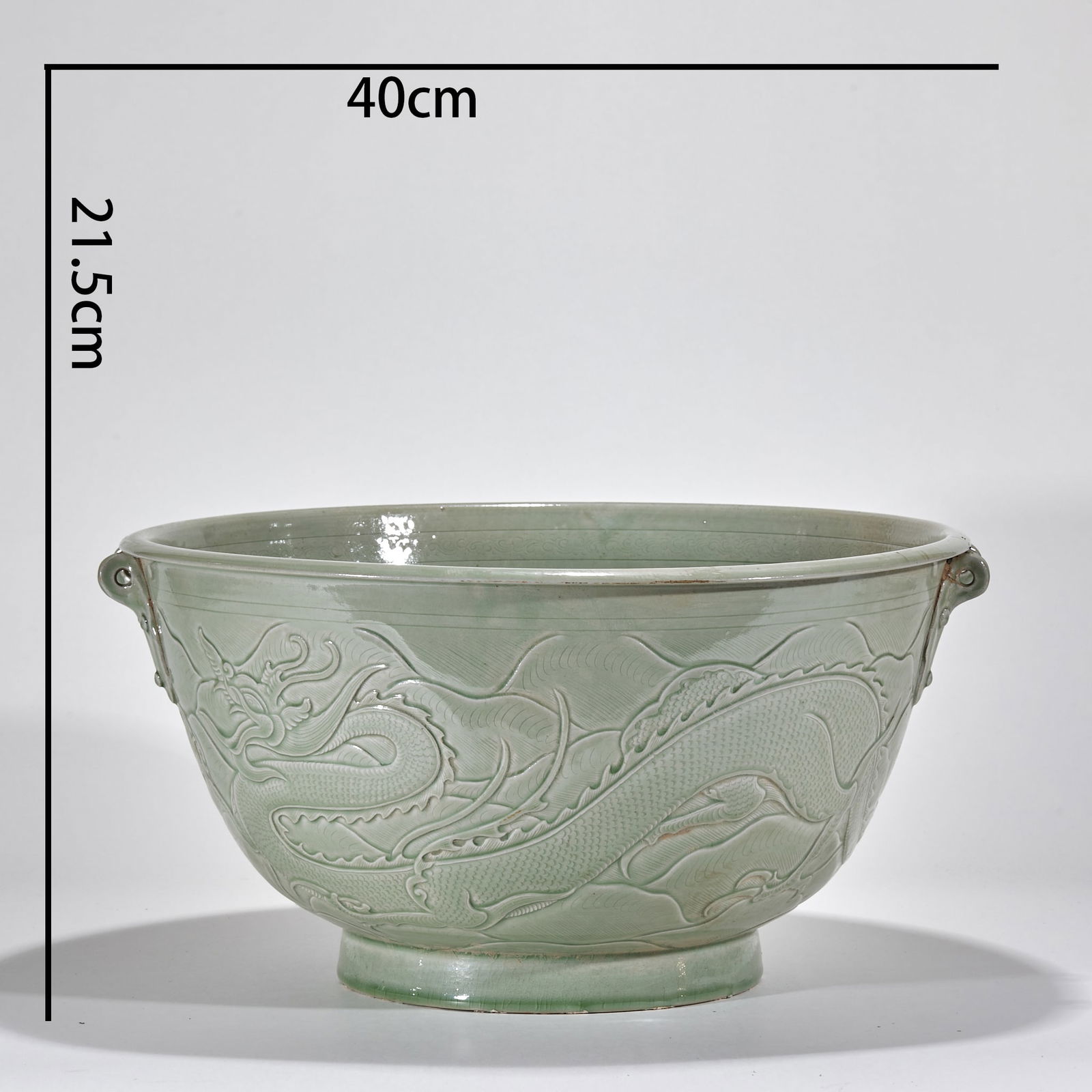 Yue Kiln Basin with Dragon Pattern: Yue Kiln Dragon Pattern Basin, with a height of 21.5cm and diameter of 40cm, fired in Yue Kiln kilns in Shangyu, Cixi and other areas of Zhejiang Province, made of celadon body with celadon glaze.