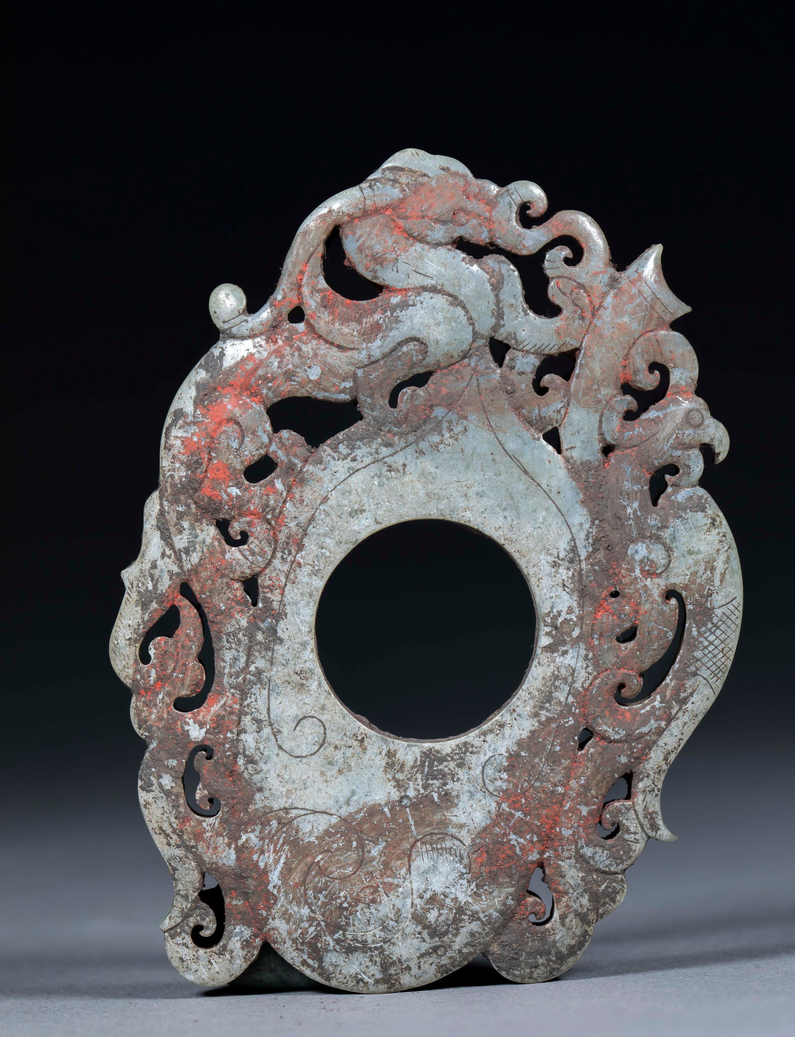 Engraved dragon and phoenix heart-shaped pendant: Openwork dragon-phoenix heart-shaped pendant. Height 0.8cm, length 9cm, width 6.5cm, weight 73g. Originated from Han Dynasty pendant, a Qing archaistic jade or modern high imitation. Hotan or local