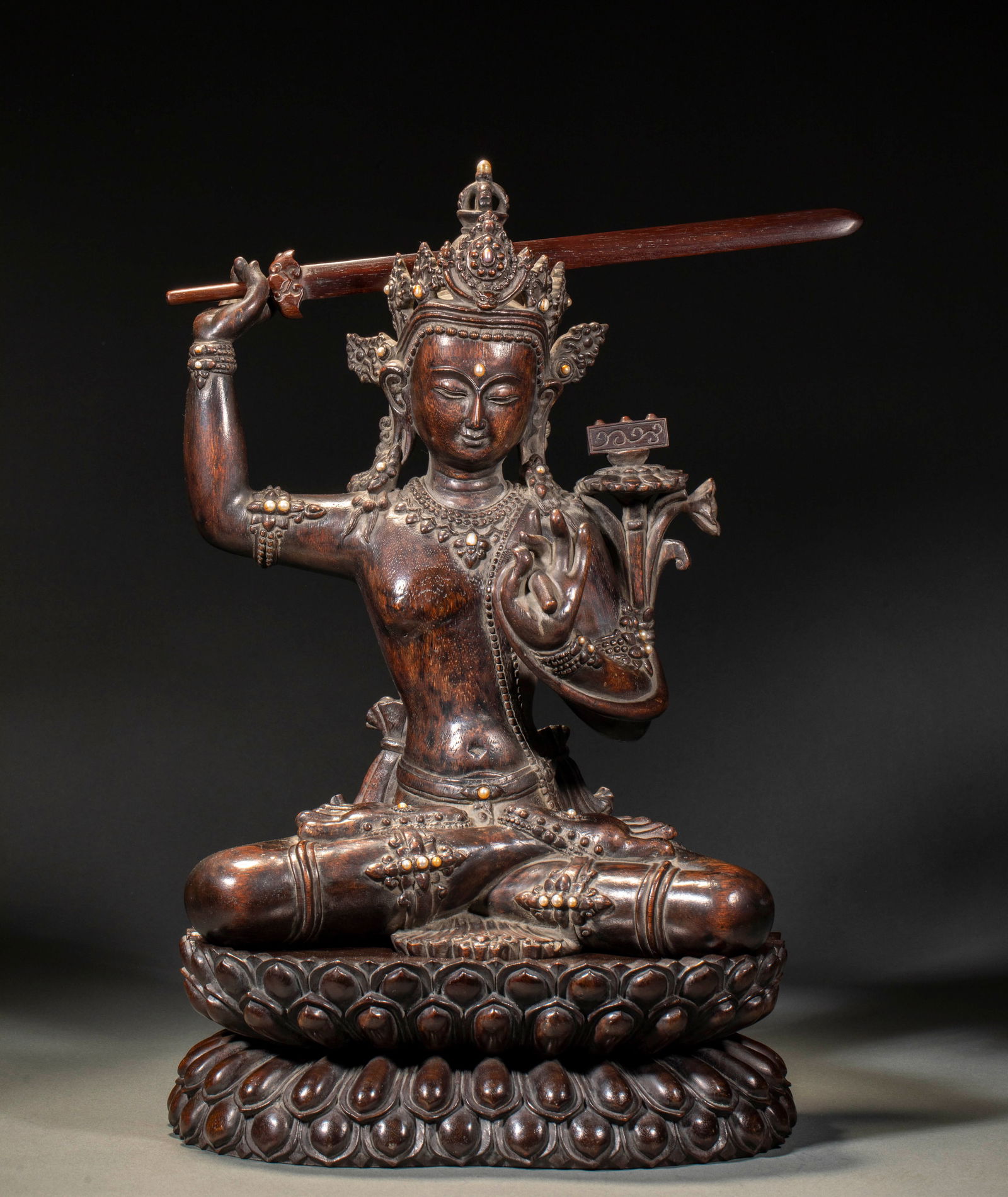 Qing Dynasty agarwood Manjusri with a sword: Qing Agarwood Manjushri Holding Sword. Height 43cm, length 25cm, width 18cm. Qing court or temple worship object, a fine agarwood statue. Agarwood (qinan or high-grade agarwood) inlaid with gold,