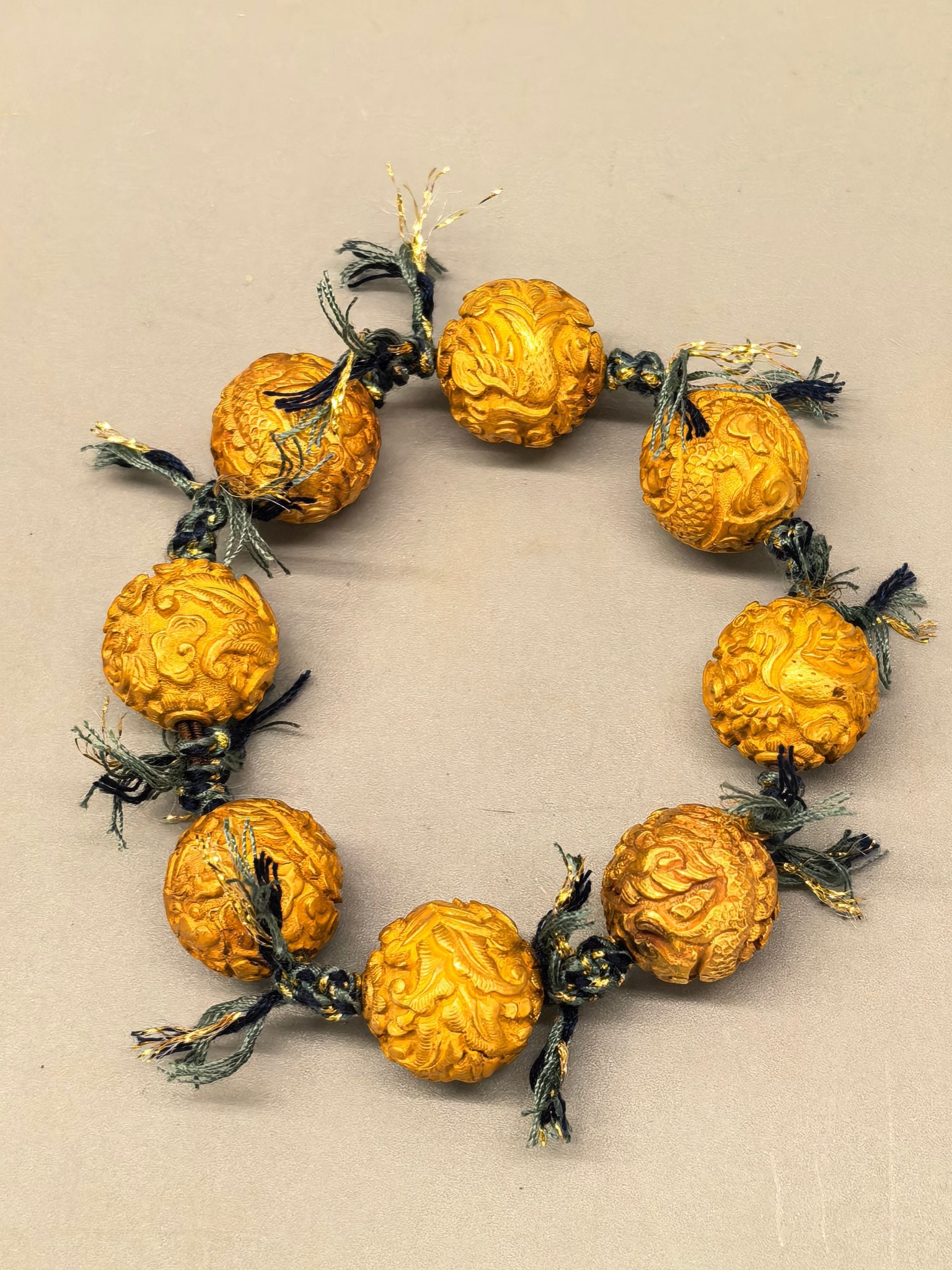 Gold and pearl bracelet with dragon and phoenix patterns: Dragon and Phoenix Gold Bead Bracelet. Single bead diameter 1.5cm, weight 58.2g. Qing court or noble ornament for "suppressing evil" or blessing. Gold (or gilded copper) with blue-green silk threads.