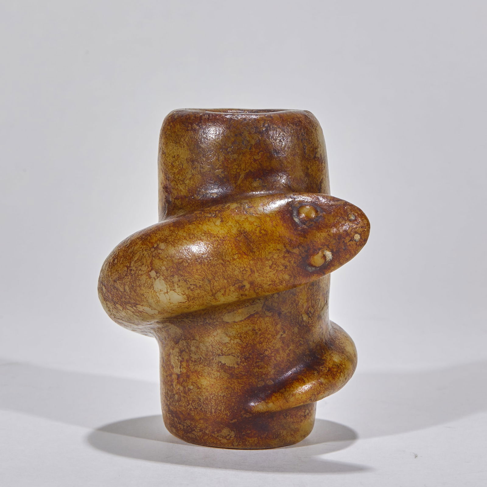 Hongshan Culture Jade Cylinder with Coiled Snake Motif (Pre-Ming Dynasty): Before the Ming Dynasty, the Hongshan Culture produced a jade tube called "Pan She" with a height of 9 cm, a diameter of 9 cm, and a weight of 645 grams. This is a sacrificial jade from the Neolithic