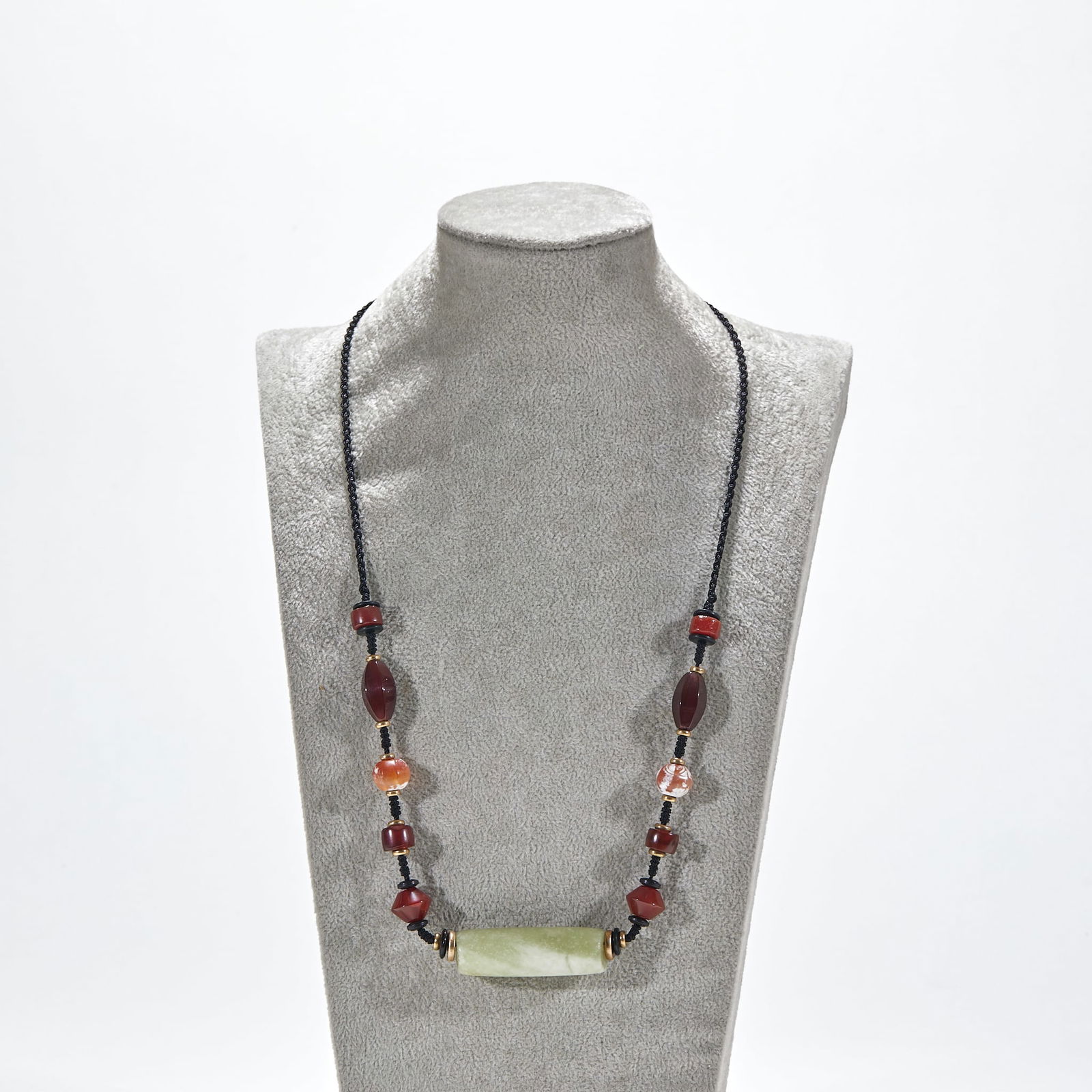 Hongshan Culture Jade Roller Pendant with Agate Beads: The red mountain culture jade ball with agate bead pendant measures 5 cm in length and 1.5 cm in width. It is a sacrificial or decorative jade from the red mountain culture (approximately 4000 - 3000
