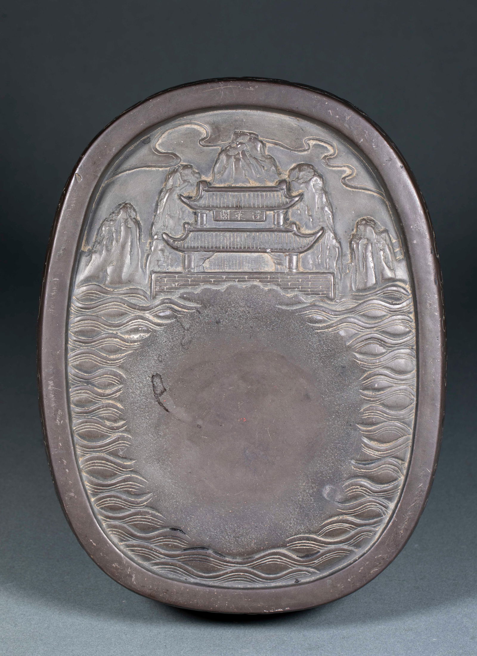 Inkstone of Immortals Gathering at Penglai Pavilion: Ink Stone Carved with Immortals Gathering at Penglai Pavilion, height 7cm, length 26.5cm, width 20cm. A scholarly desk object of the Qing Dynasty themed with "Penglai Pavilion", symbolizing a