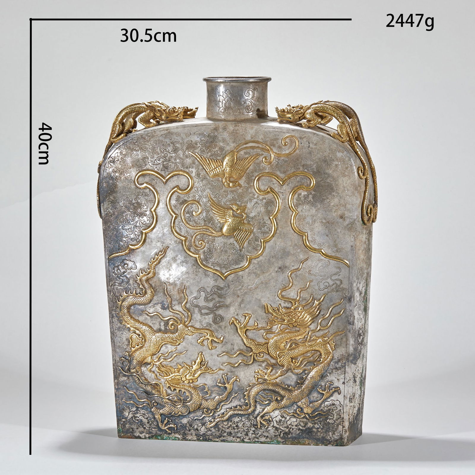Gilded Silver Flat Flask with Dragon and Phoenix Pattern: Silver-Gilt Flat Flask with Dragon and Phoenix Patterns, height 40cm, length 30.5cm, thickness 11cm, 2447g. A wine vessel of the nomadic peoples of the Tang or Liao Dynasty, influenced by Central