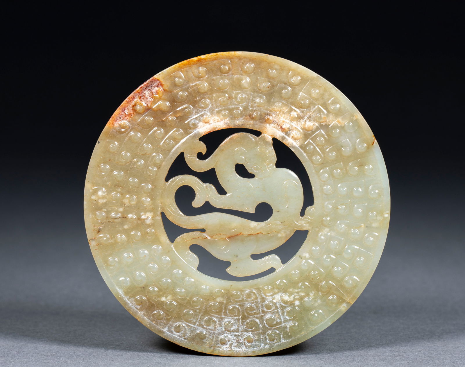 Hotan Jade Dragon-shaped Bi Disc: Hotan Jade Dragon Bi, thickness 0.4cm, diameter 10cm, 68g. A Han or earlier high?ancient out?framed jade bi. Hotan jade with natural yellow?brown discoloration and calcification. Made with openwork
