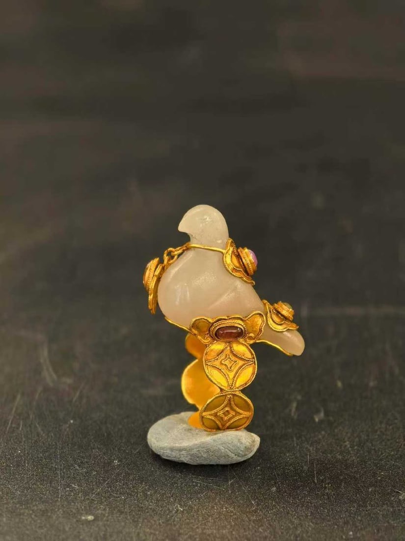 Hotan Jade Ring with Bird Holding Gold: Hotan Jade Bird Gold Ring, 14.76g. Qing or modern “gold?inlaid jade” jewelry. Hotan white?jade bird, gold band, inlaid with rubies and tourmaline. Made with round carving, filigree, and