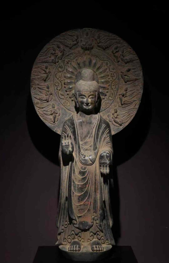 Gilded Standing Buddha with Flying Apsaras Halo, Northern Wei Dynasty: Northern Wei Gilded Standing Buddha with Flying Apsaras Mandorla, height 153cm. A gilded stone standing Buddha of the Northern Wei period (386–534). Bluestone with remaining gold foil. Crafted with