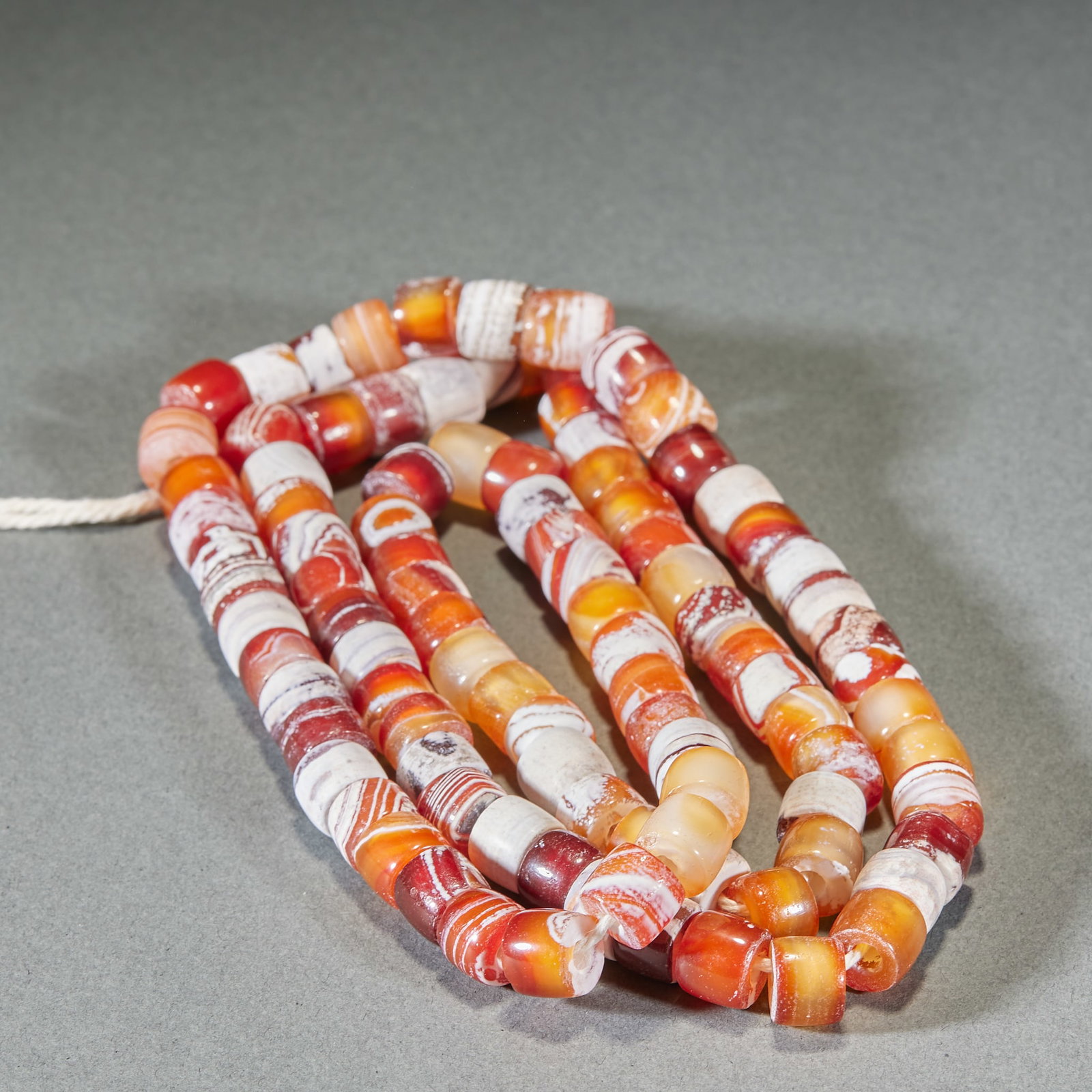 100 Beads of Red-White Banded Agate: Agate Red-and-White Beaded Strand, 100 Beads, Length 1.1cm, Width 0.8cm. Imported to China from West / Central Asia (ancient Persia / Sasanian Empire) or produced in China from the Han to Tang Dynasty