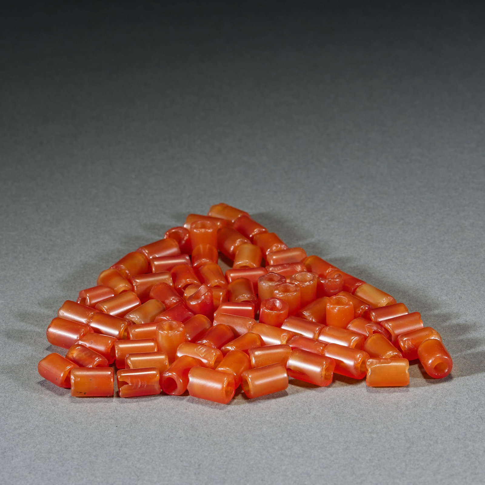 75 Pcs Agate Short Tubular Beads: Seventy-five agate short tube beads, L. 1cm, W. 0.8cm, Liao–Jin Dynasties (ancient bead ornaments, excavated/hereditary, complete set); natural red agate; crafted with agate grinding and drilling
