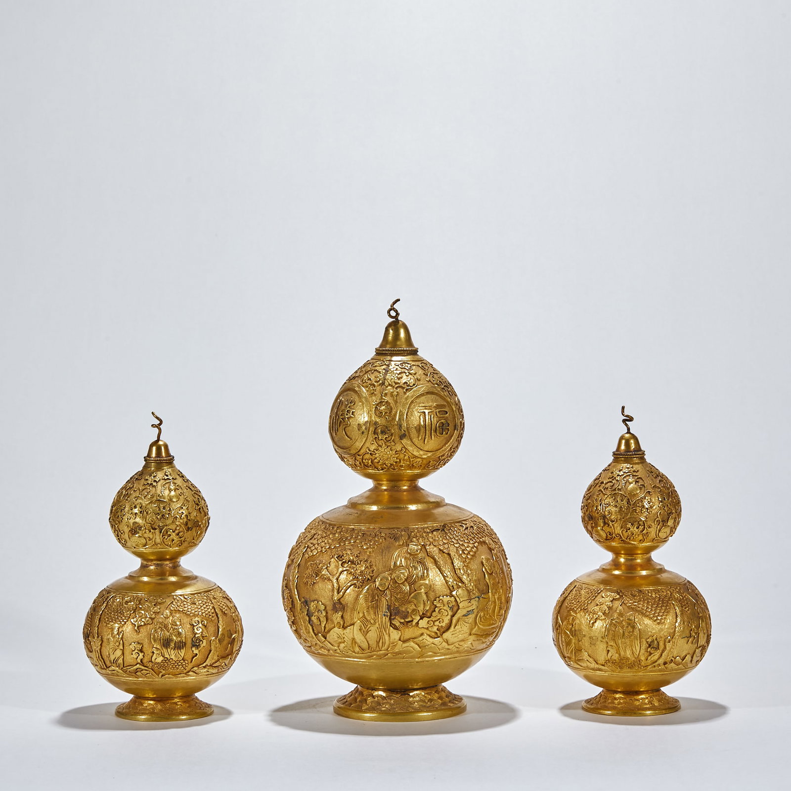 Group of Gilt Bronze Gourd Ornaments with Relief Engraved Fu, Lu & Shou Star Gods: Group of Gilt Bronze Gourd Ornaments with Relief Engraved Fu, Lu & Shou Star GodsLarge: H 28 cm, Belly Diam. 15 cm; Small: H 20 cm, Belly Diam. 11 cm