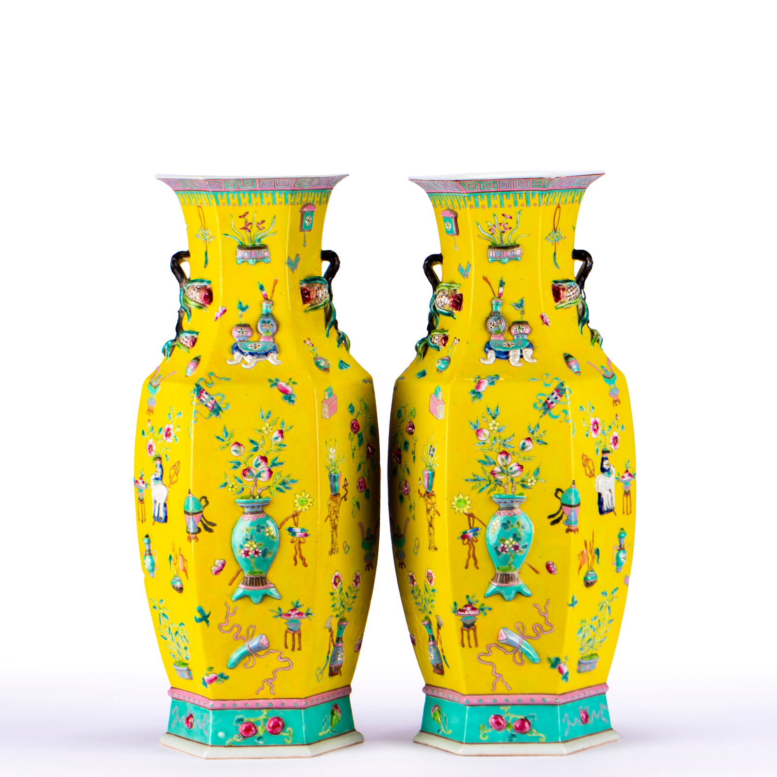 A pair of six-edged appreciation bottles in Qing famille rose Fushou study room.: Two pairs of hexagonal porcelain bottles, the bottles are bright yellow. Three-dimensional Bo Gu patterns are piled on the surface of the bottle body, and vases, utensils, flowers, fruits and