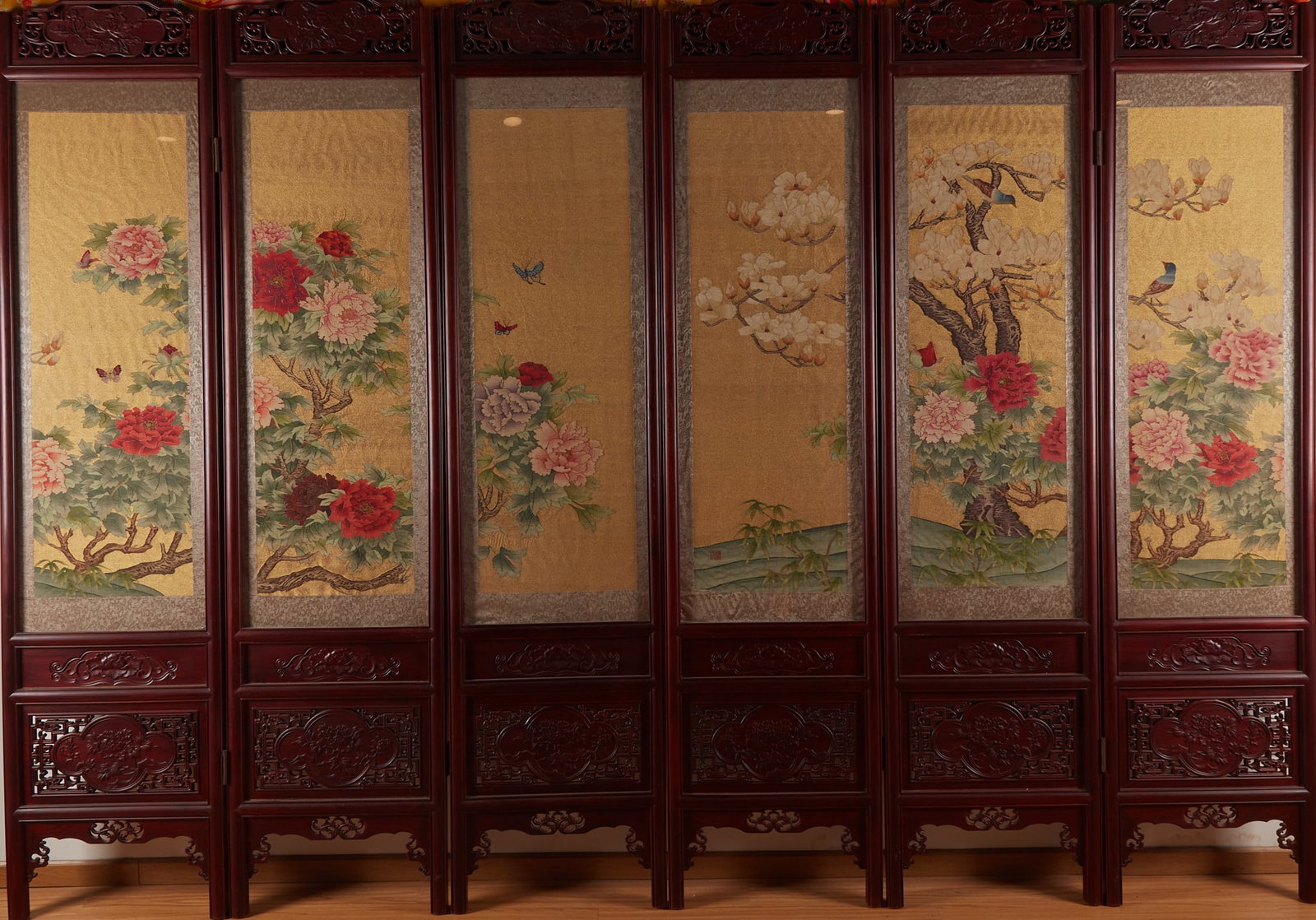 Rosewood silk flower-and-bird screen: Six complete sets of floor folding screens, dark wood carving frame. The base of the screen core is gold, painted with peony and magnolia, matched with butterflies and birds. The flowers are red,
