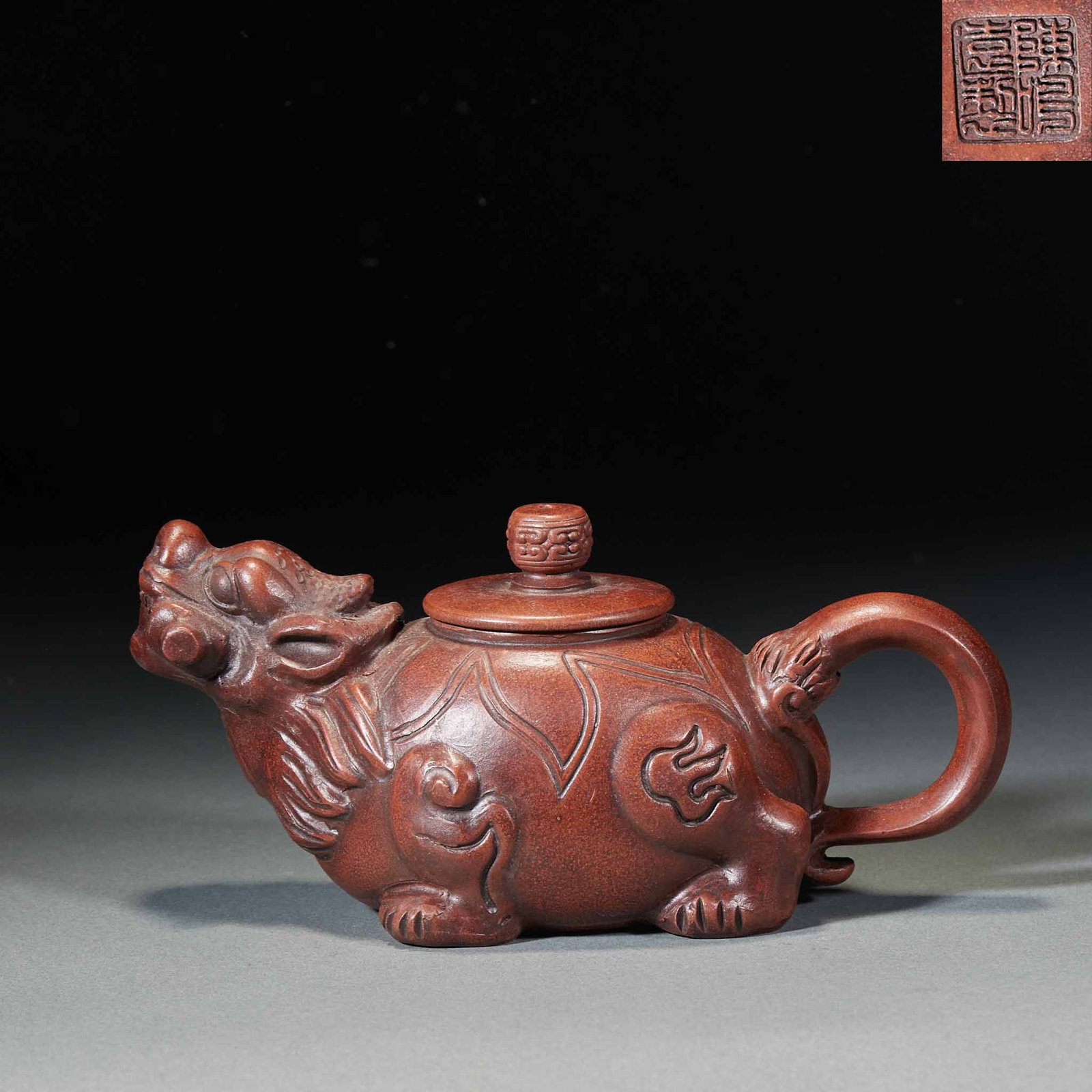 Chen Mingyuan Dragon Turtle teapot: Purple sand animal-shaped pot, reddish brown all over. The whole device is shaped like a beast, with the head of the beast as a pot flow, the body of the beast as a pot body, the handle of the pot