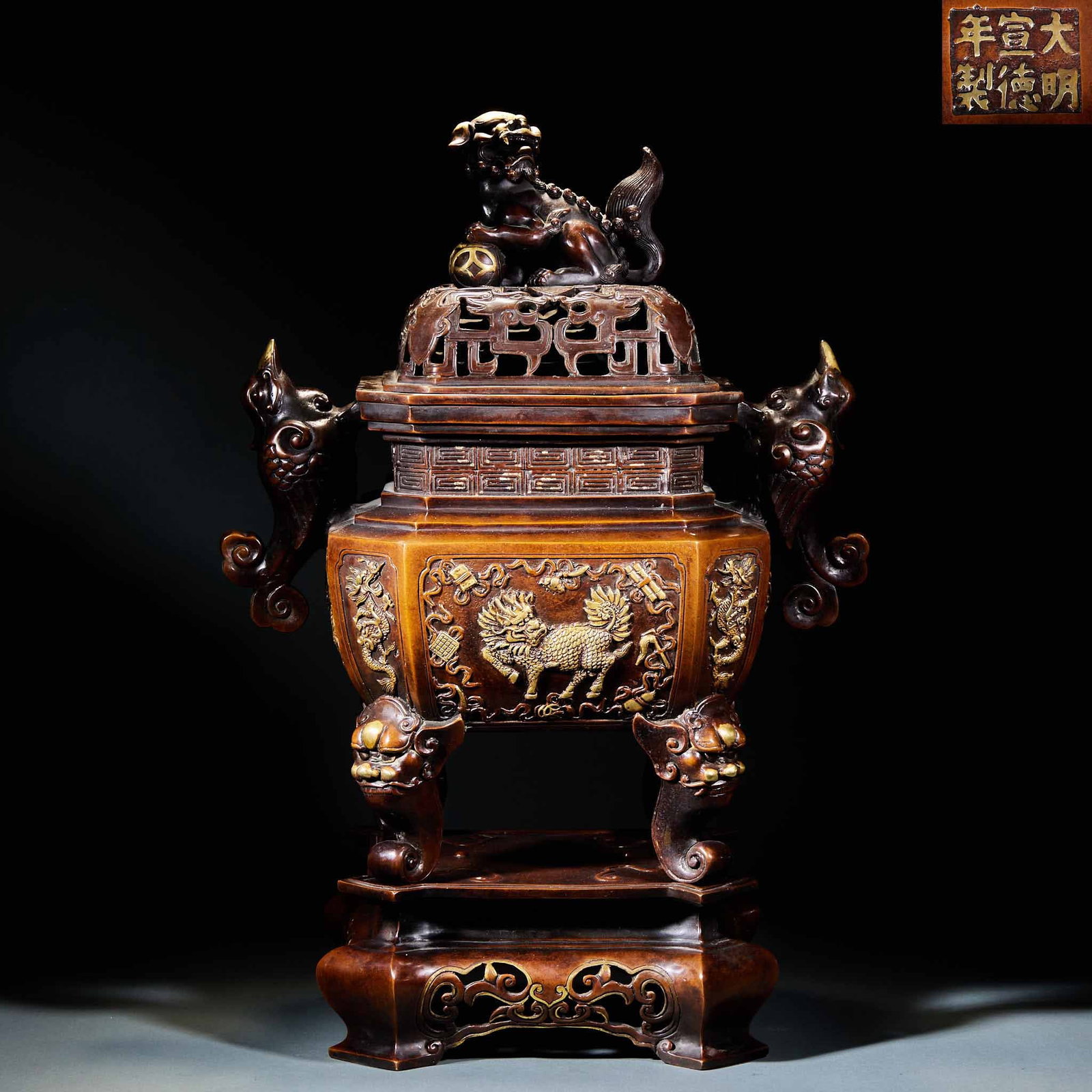 Daming Xuande annual bronze gilt lion twist aromatherapy stove: Copper, under the "Daming Xuande Year System". The furnace cover squats on the beast button, and the cover surface is hollowed out; The furnace body is square, with phoenix-shaped ears on both sides,