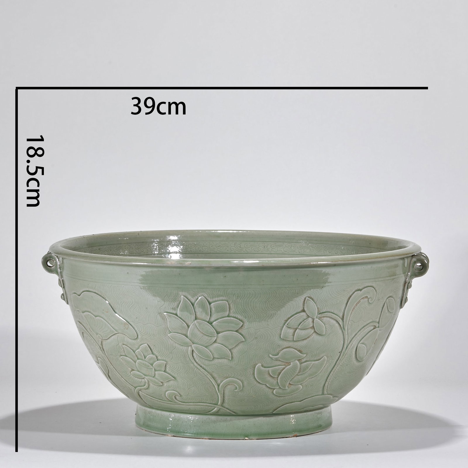 Yueyao Lotus and Pisces Pot: The caliber is 39cm and the height is 18.5cm. Wide mouth, arc belly, circle foot, and double-tied ears on both sides of the mouth. The whole body is green glaze, the outer wall of the basin is carved