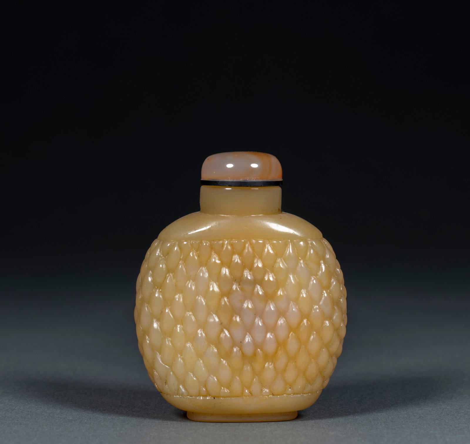 Agate snuff bottle: Agate texture, overall flat round pot body. The pot body is carved and dustpan is woven with texture, and the texture is arranged neatly. With agate pot cover made of the same material, with black