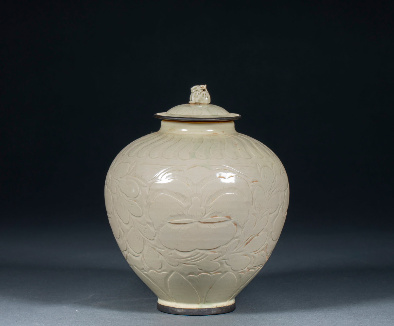 Ding kiln carved flower pattern jar: Straight mouth, short neck, rich shoulders, bulging abdomen, lower abdomen gradually closing, and full circle. The edge of the tank mouth and the edge of the ring foot are covered with metal inserts.
