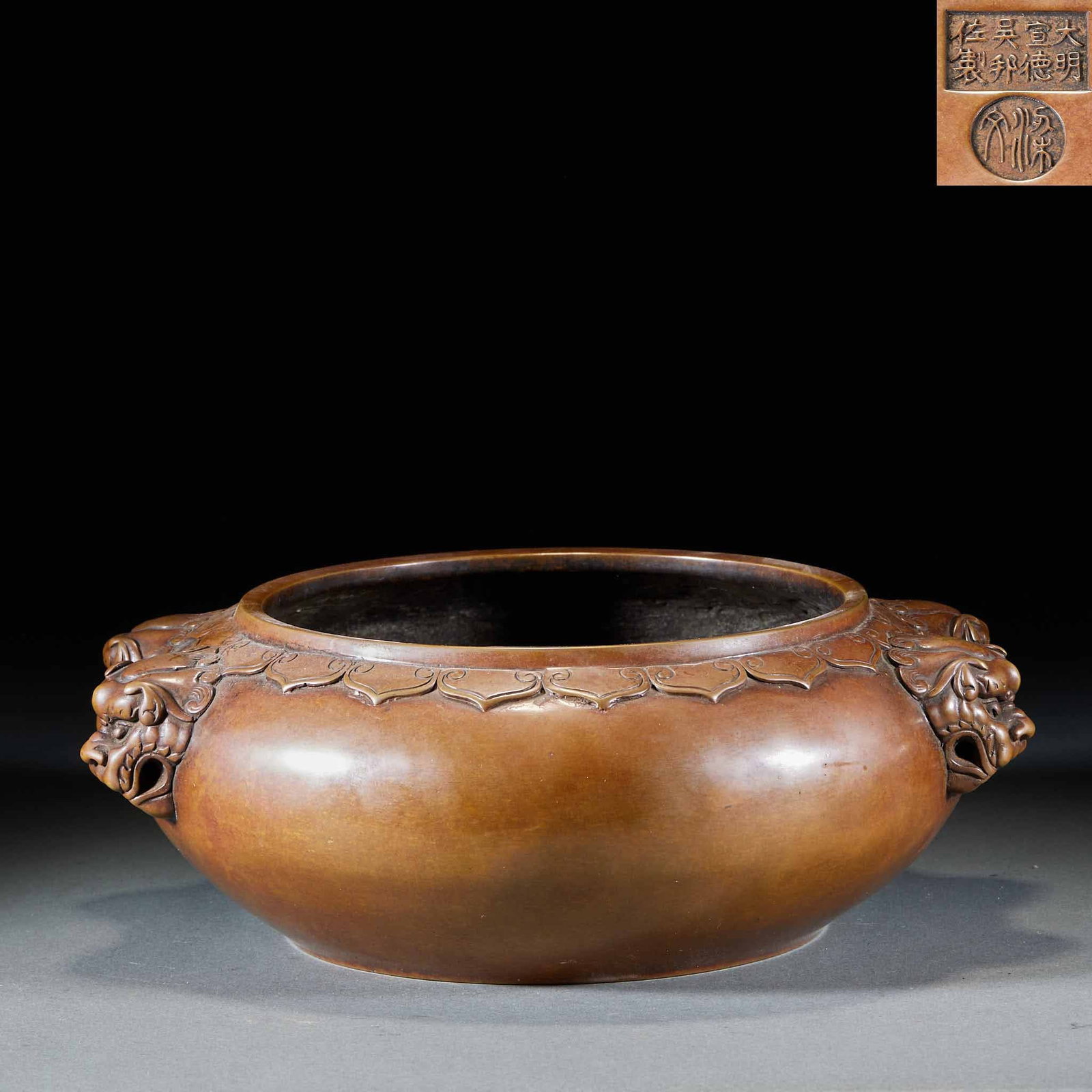 Daming Xuande Wu Bangzuo incense burner: The copper furnace body is bowl-shaped with a wide mouth, flat and bulging, and full circle. The two sides of the furnace shoulder are provided with three-dimensional lion head ears, and the mouth is