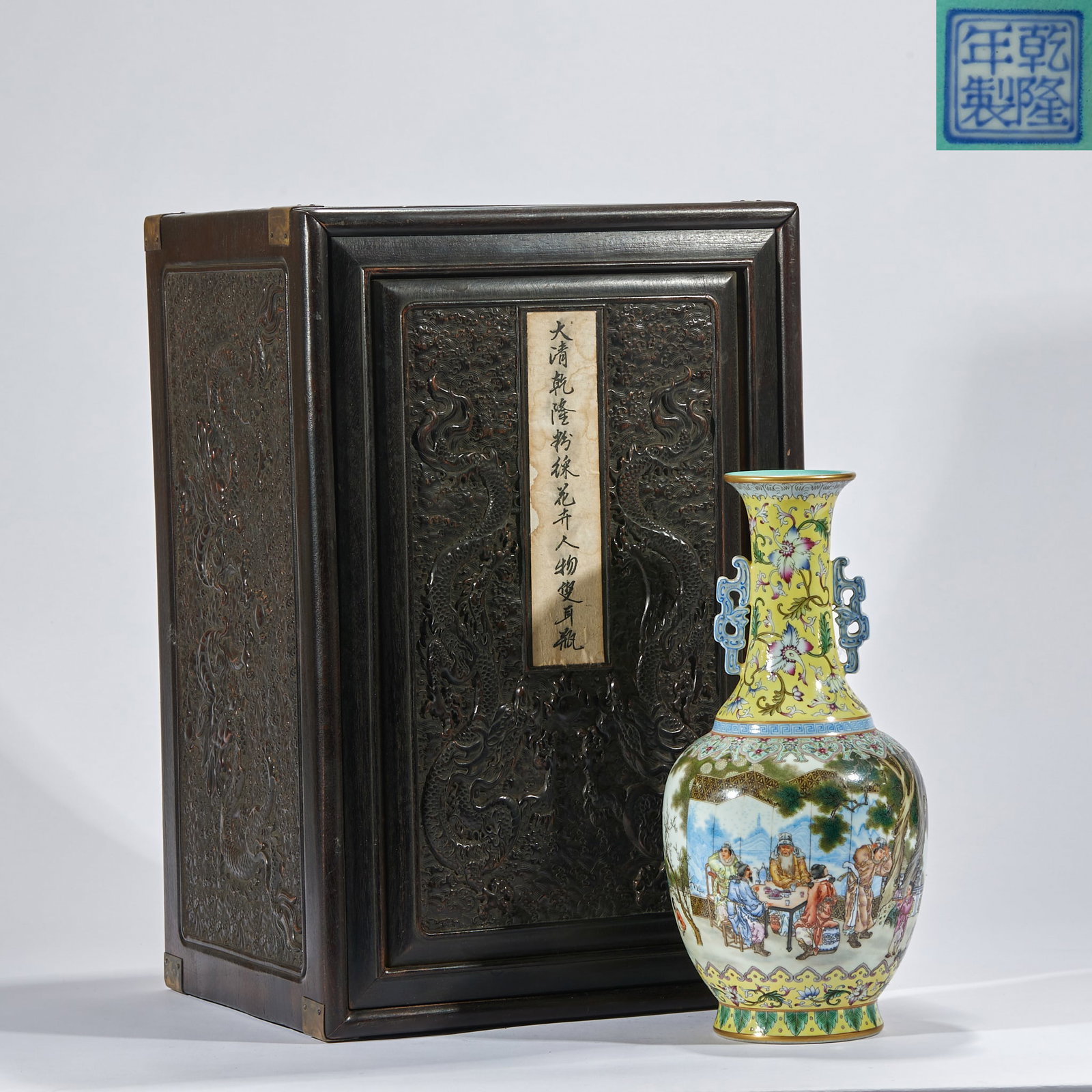Daqingganlong pastel flower figure ear bottle: The bottle is equipped with an original carved wooden box with dragon pattern. The surface of the wooden box is carved with Yunlong, and a paper label is attached. The bottle body is equipped with