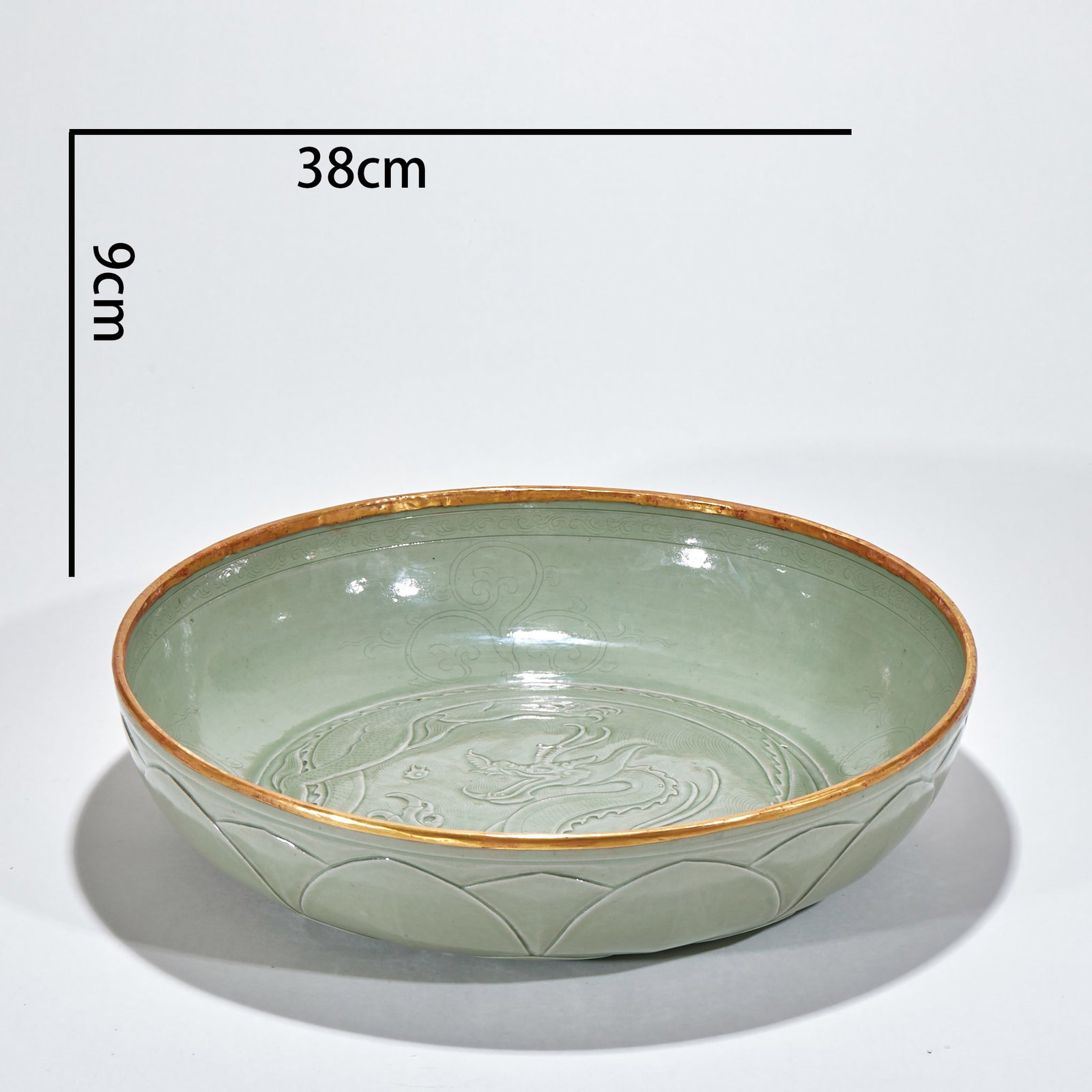 Kiln-covered dragon pattern plate: The whole body is painted with green glaze, and the edge of the mouth is covered with gold-plated metal. The inner bottom of the device is engraved with dragon patterns, and the inner wall is