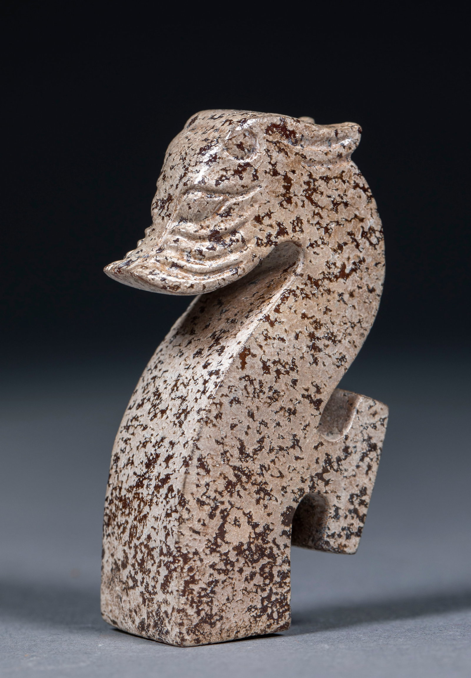 snow-capped mountains: As a whole, it is a jade hook with a dragon head, and the jade is all over the gray and dark brown mottled. The hook head is carved into a dragon head shape, and the facial features, snout and beard