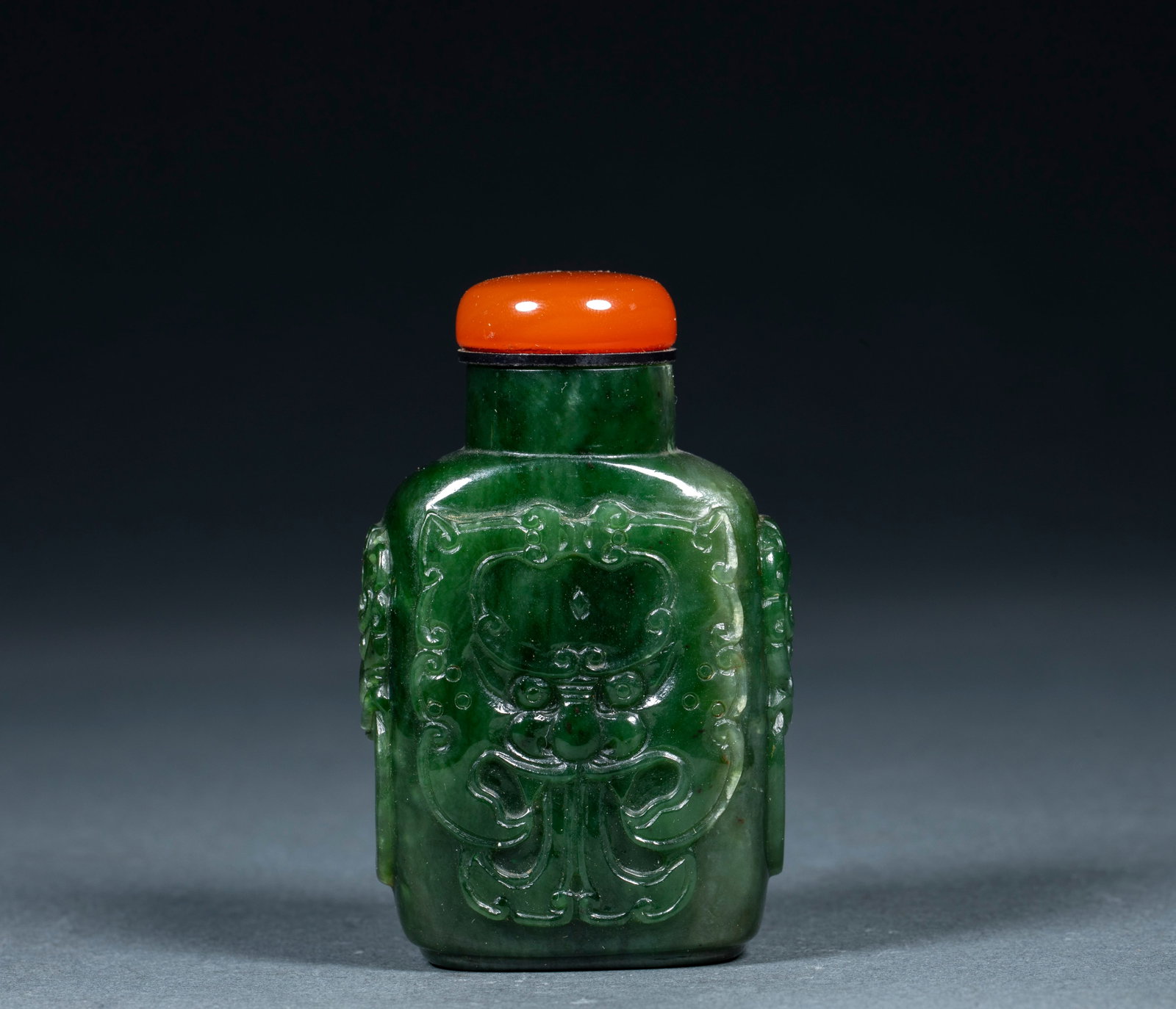 Jade embossed animal face snuff bottle: Hetian jasper texture, square flat body, carved on both sides of the first ear. The front of the pot body is embossed with a combination of bat and chin, and the lines are layered gently. With