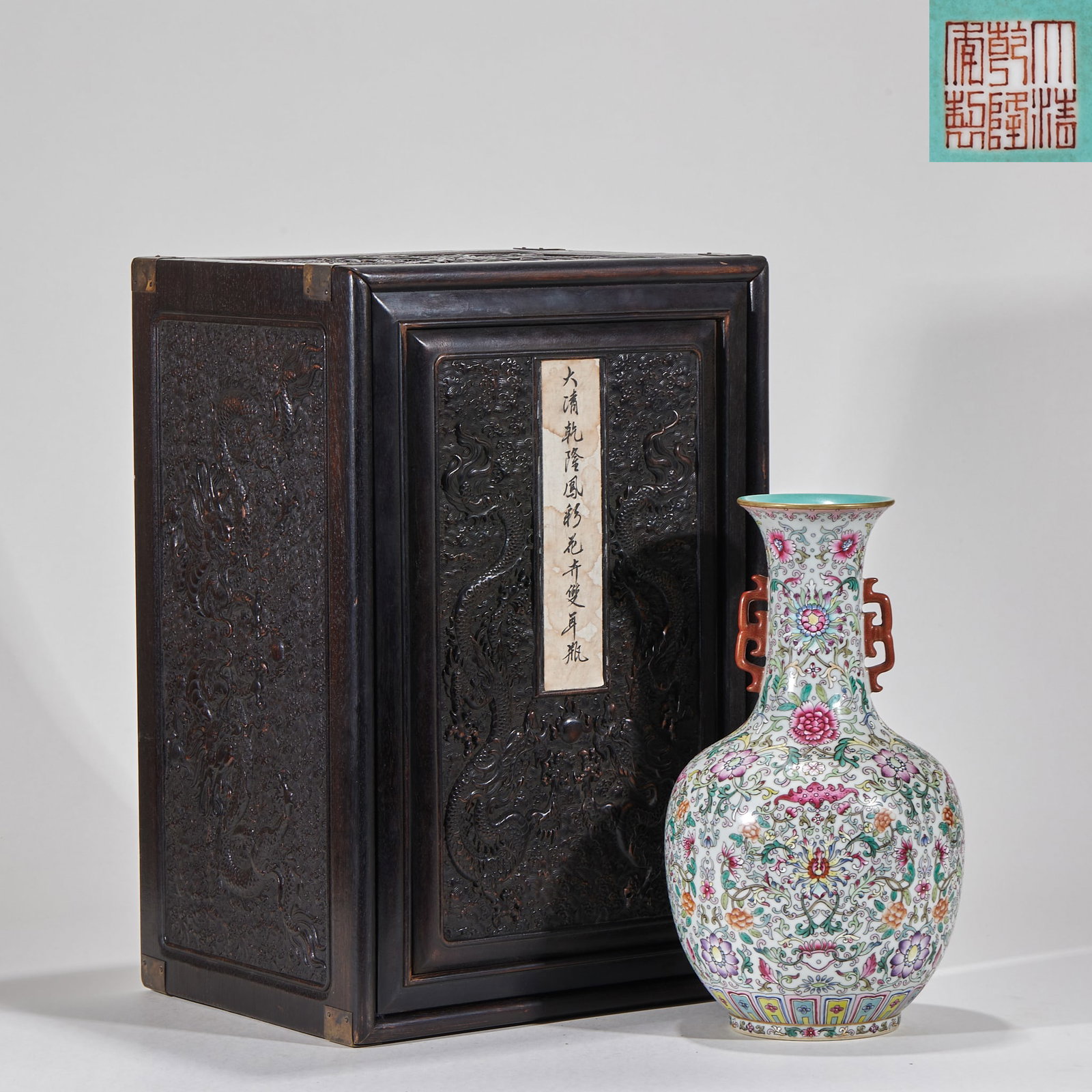 Daqingganlong annual pastel flower ear bottle: Porcelain display bottle, with the red color of "Qing Qianlong Year System" at the bottom. Lip curl, long neck, bulging abdomen, circle feet, and a pair of red color dragon ears are set on the neck. T