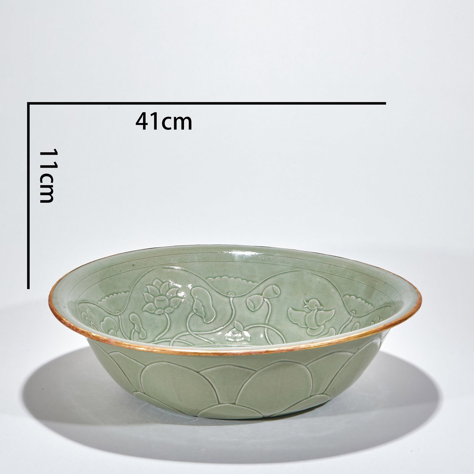 Yue Yao Bao Jin flowers and plants hand cleaning basin: Open, arc wall, circle foot. Apply green glaze all over the body, and the glaze color is warm and moist. The bowl is carved with lotus flowers, lotus leaves and waterfowl patterns, and the lines are