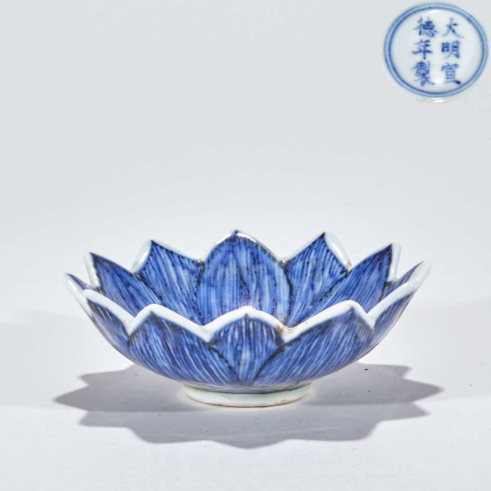 Daming Xuande Annual Blue and White Lotus Wash: The bowl is lotus petal-shaped, and the mouth edge and outer wall fluctuate with the lotus petal. White glaze is applied to the whole body, and the lotus petal texture is painted in blue and white. Th