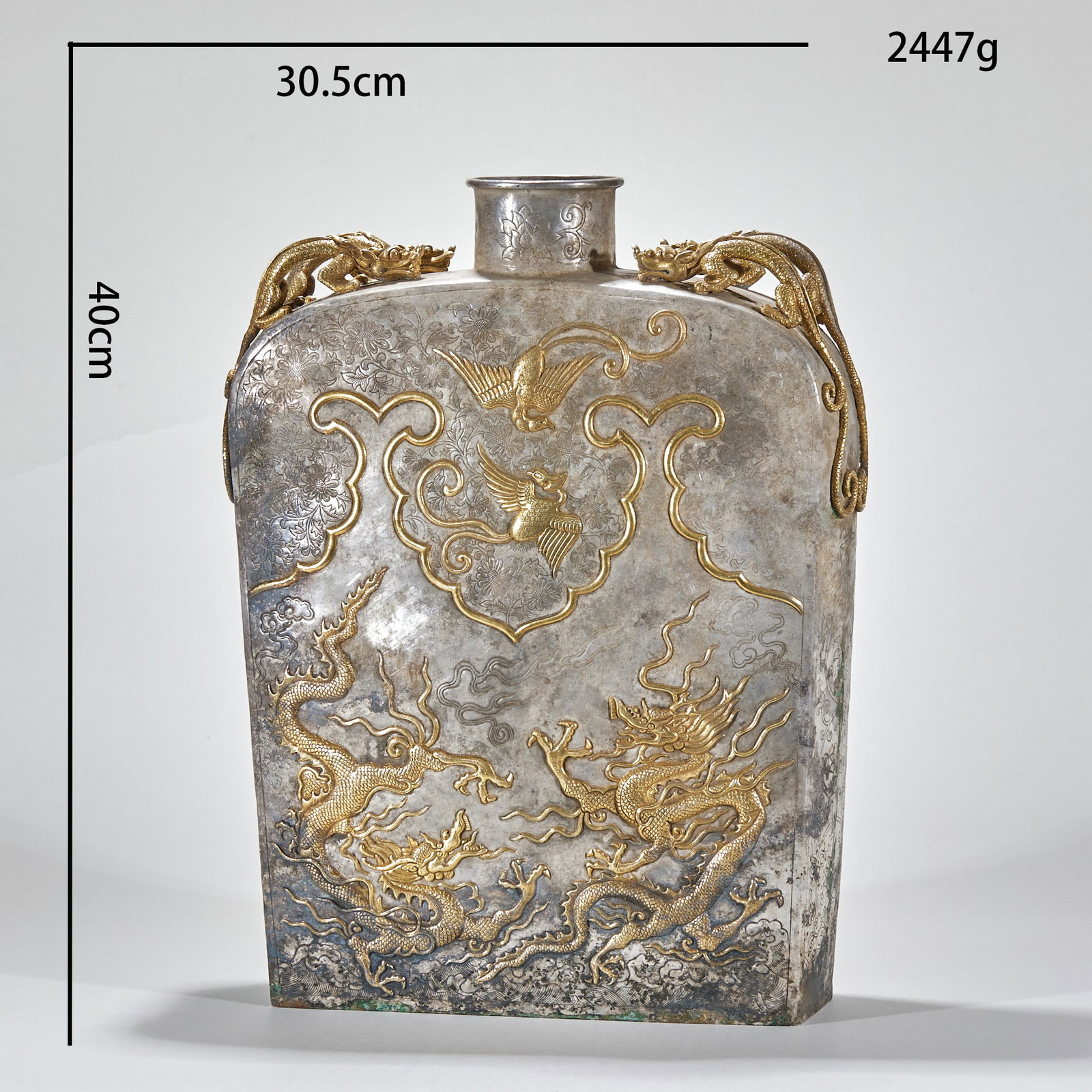 Silver-gilded flat pot with dragon and phoenix patterns: Silver body, main body decorated with gold. The object is flat and square, with a small mouth and a straight neck, and two gilded dragons are attached to both sides as ears. The surface of the device 