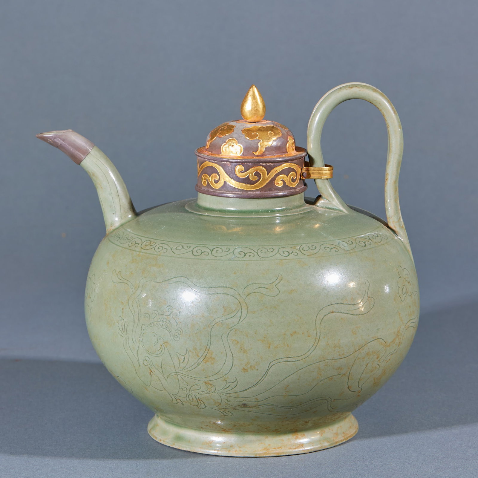 Celadon Bao kou Fei Tian zhi Hu: The pot body is green glaze porcelain, and it is full and round. The body is carved with flying patterns, the flying clothes are elegant, and the surrounding is supplemented by grass fringing. One