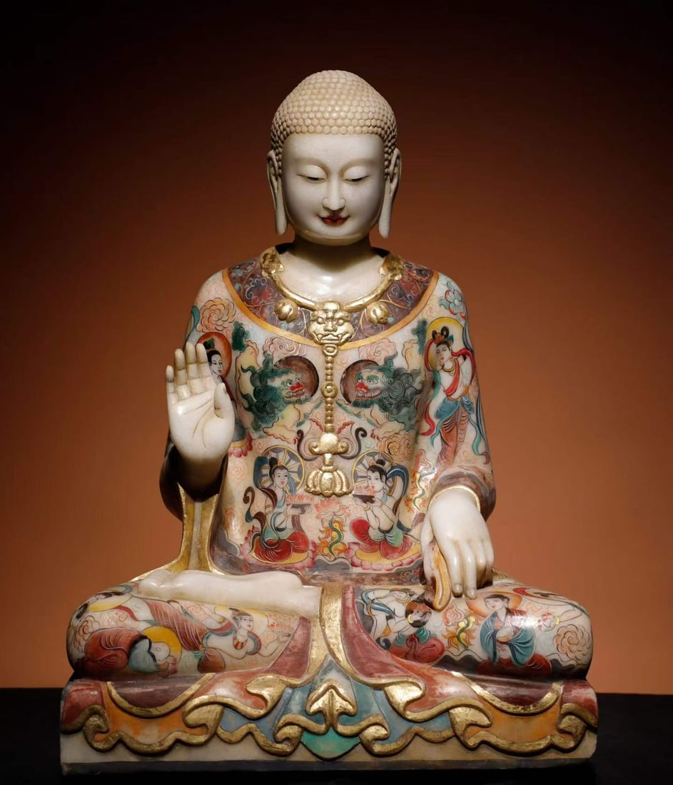 White marble painted Buddha statue: Made of white marble, the Buddha sits in a crouch, with fearless seal on his right hand and touching his knee with his left hand. The Buddha's head has a neat spiral hair and a calm face. The whole bo