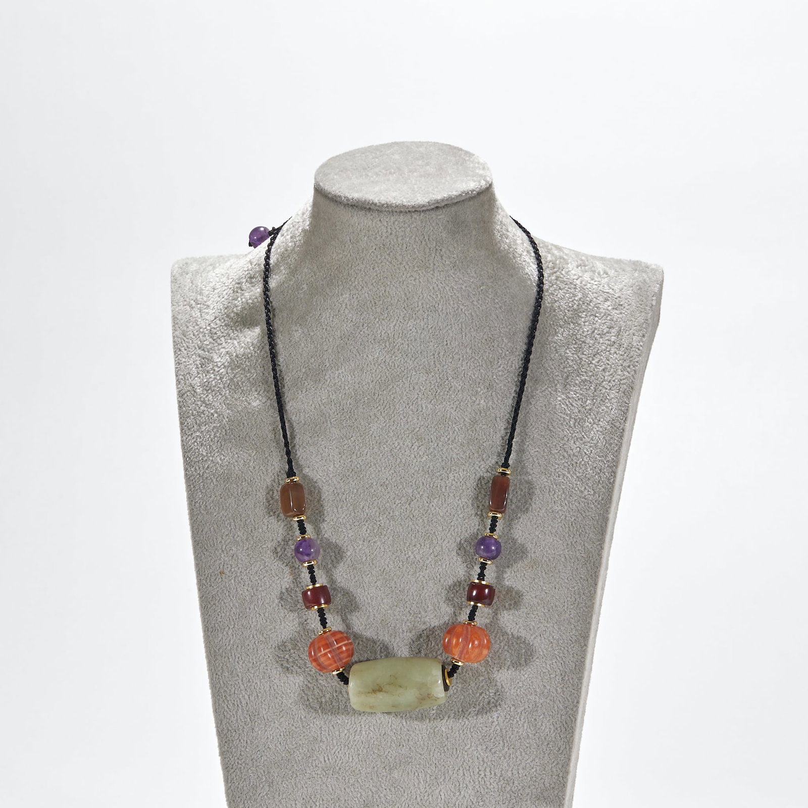 Hongshan Culture jade roller with agate crystal pendant: Braided black rope is a chain, and the main part is a rectangular blue and white jade tube bead. Red agate melon bead, red-brown agate bead and amethyst bead are arranged on both sides in turn, and