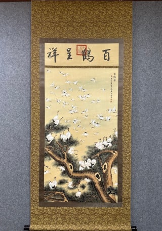 Shen Quan Baihetu Silk Vertical Axis: The silk book is colored and vertical, and the original silk is mounted. The words "Hundreds of cranes are auspicious" are written on the banner above the painting heart, and the seal is made by a cym