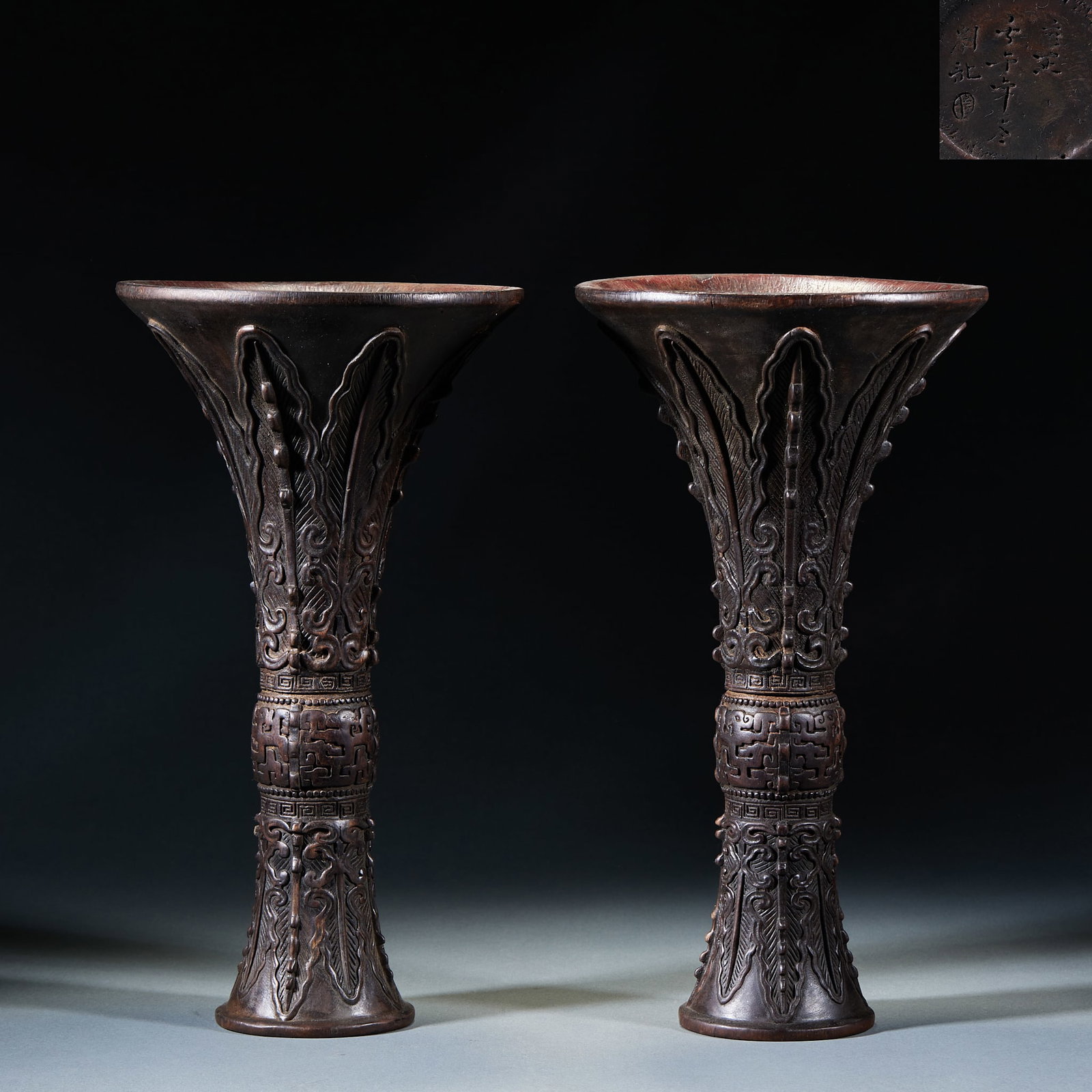 A pair of agarwood flowers in Yongzheng year: The flower pattern is trumpet-shaped, with a long neck, a bulging belly in the middle and a circle foot at the lower end. The whole body is embossed, and the banana leaf pattern is carved from the
