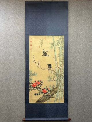 Silk copy of Wang Yuan Zhu Mei newspaper spring picture: Dark blue embroidered silk frame. The painting heart is an antique silk book, painted with plum blossoms, bamboo and camellia. Plum branches are oblique, and there are two starlings on the branches,
