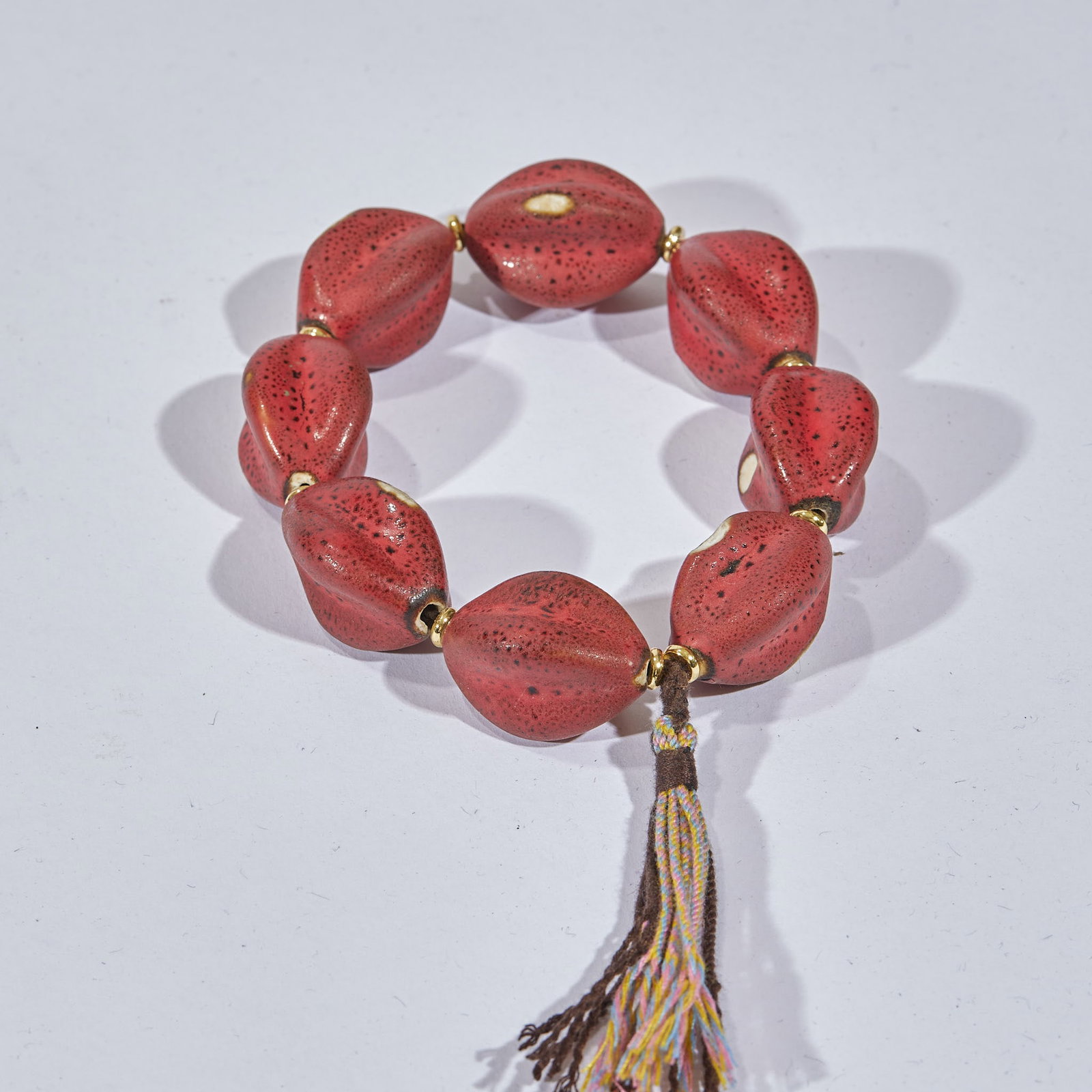 Jiuhong bracelets: The bracelet is made of nine bionic fruit-shaped beads connected in series. The beads are all red with black spots on the surface, and each bead is inlaid with gold spacers at both ends. The end of