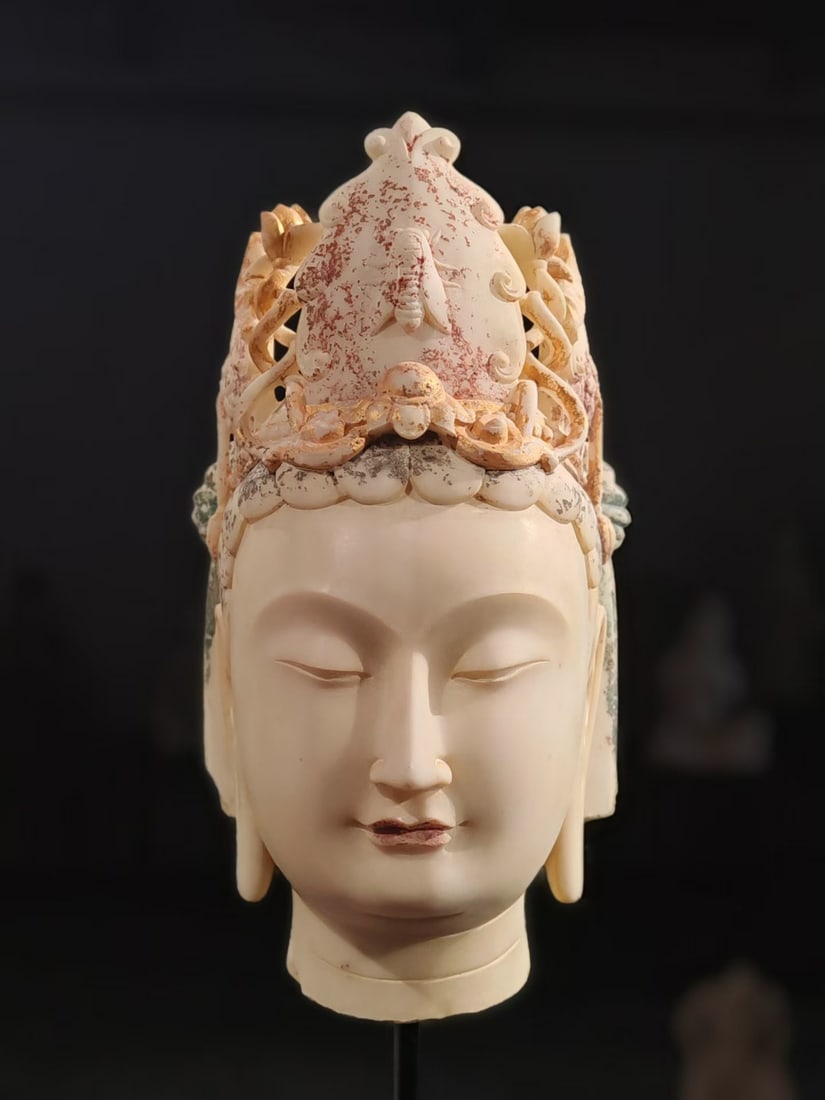 White marble painted cicada crown bodhisattva head: Baishi carved Guanyin's head, wearing a complicated hollow crown, and carved cicada patterns and lotus scroll grass patterns on the crown, leaving scarlet and gold paintings. Guanyin's eyes are
