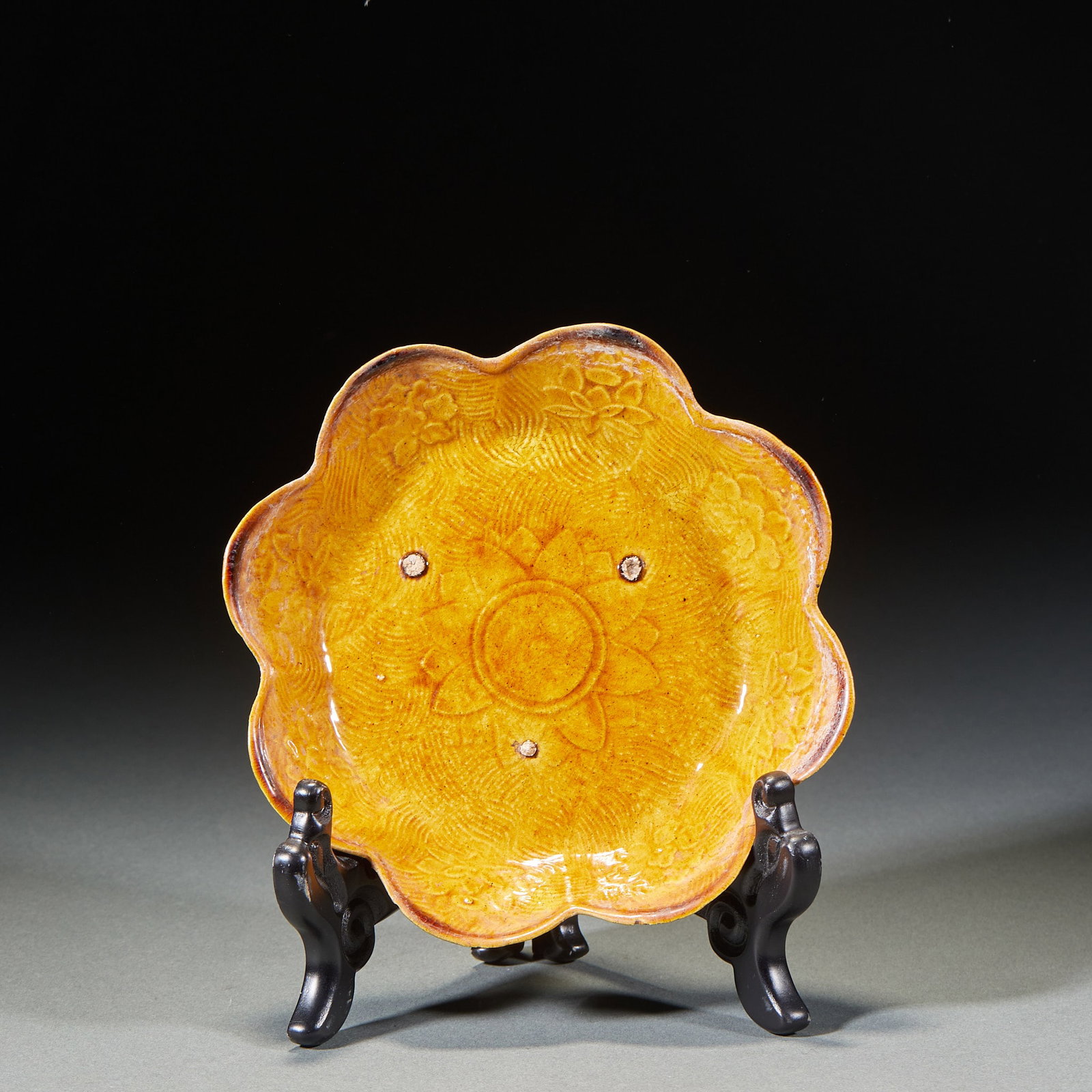 Yellow glazed lotus dish: The flower mouth is folded along the porcelain plate, and the body is painted with bright yellow glaze. The mouth edge is in the shape of six petals. The dish is carved with water ripples, the core