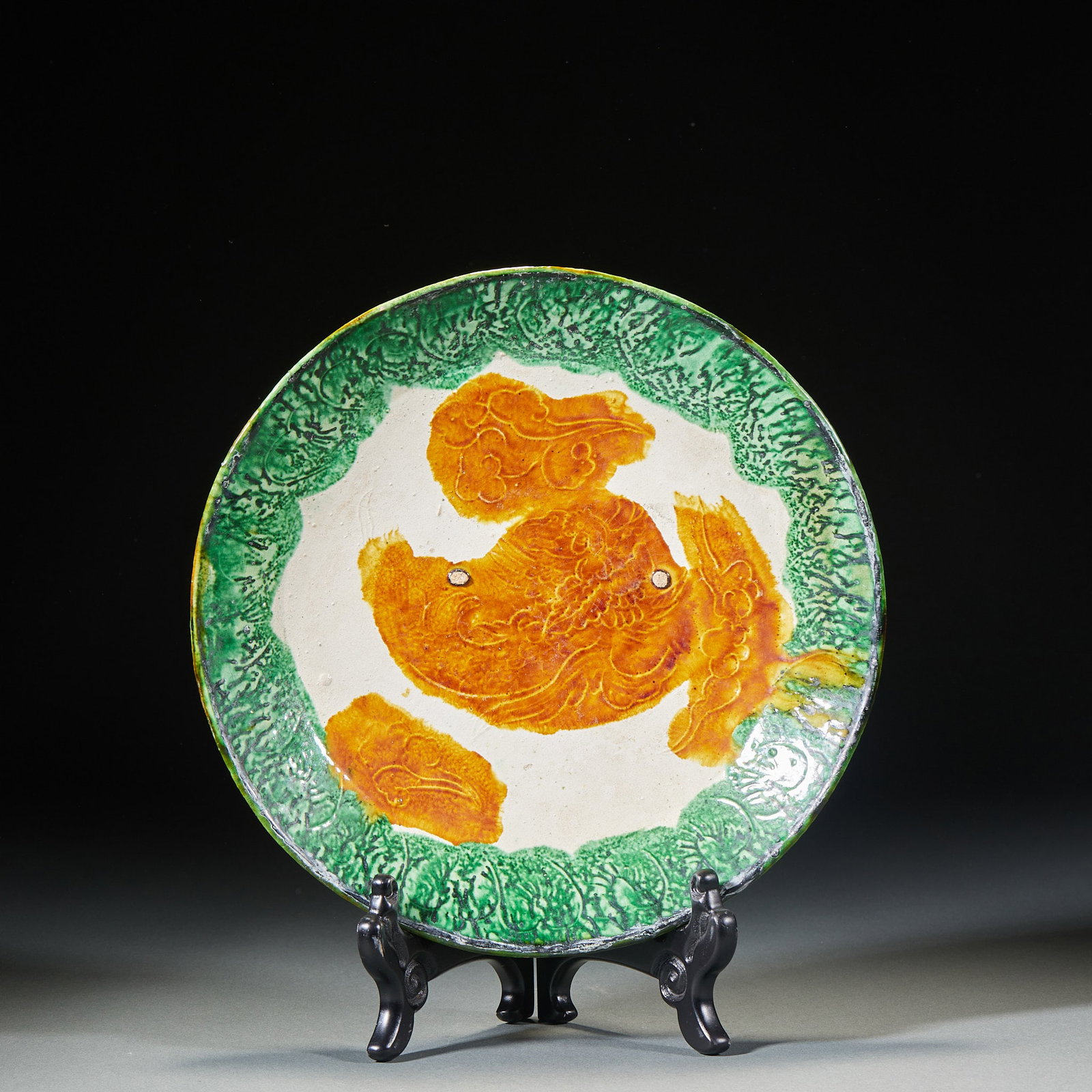Tri-colored plates before Ming Dynasty: Round porcelain plate, with green glaze applied to the edge and outer wall, white space left in the inner part of the plate, yellow color pattern printed on the auspicious beast, moire around the ausp