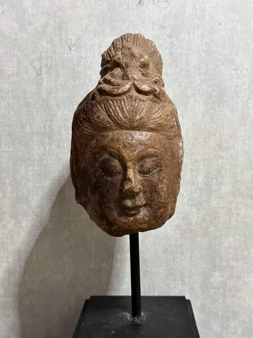 White marble bodhisattva head: The head of a stone bodhisattva remains, and the lower jaw and both sides are incomplete. The stone is yellowish brown, and the surface is covered with mottled traces formed by years of erosion. The