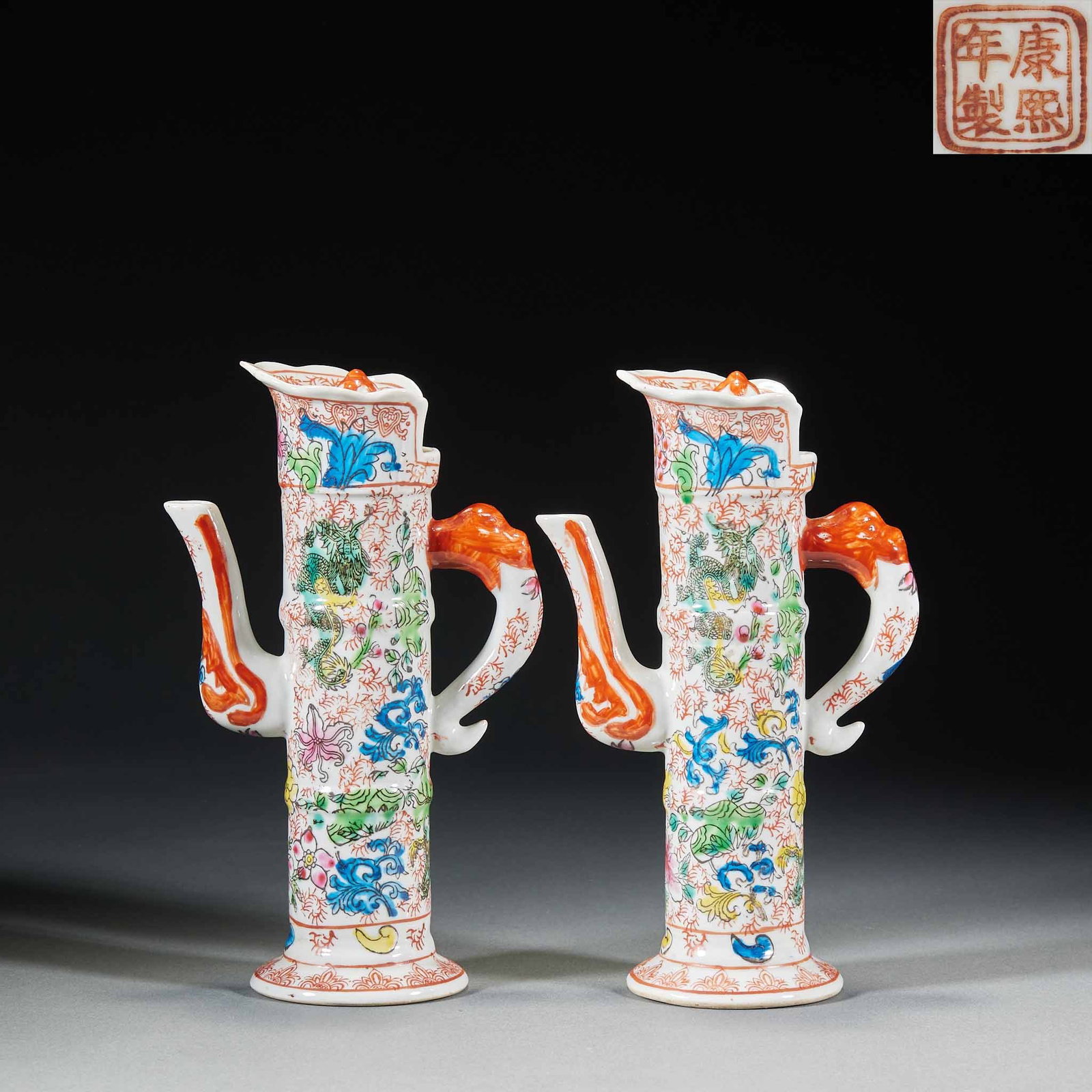 A pair of pastel flower-patterned monk's cap pots in Kangxi of Qing Dynasty: Paired porcelain pots, with the shape of Domu pot, dragon-shaped handle and slender spout, are painted with colorful flowers and dragons and dragons, with rich and gorgeous colors, and the red seal of